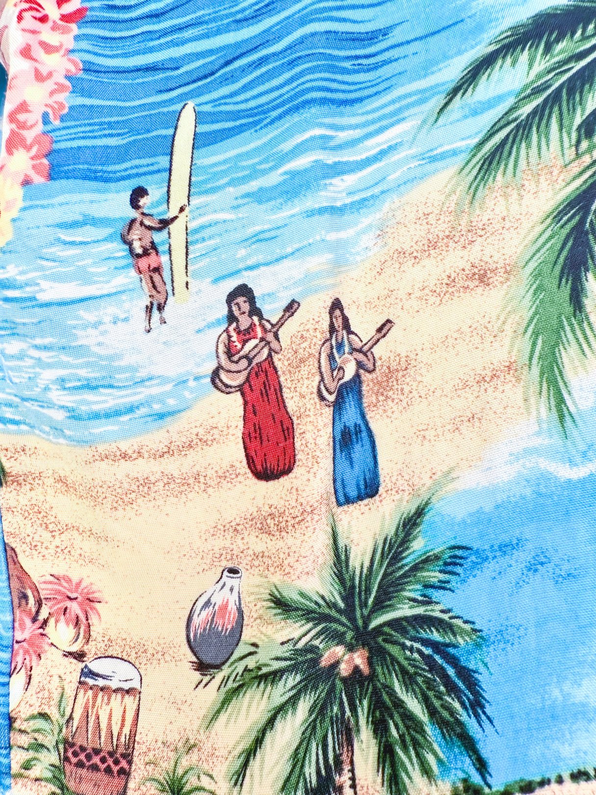 Blue 1960s women's Aloha Darling Top featuring a tropical beach scene with musicians and a surfer.