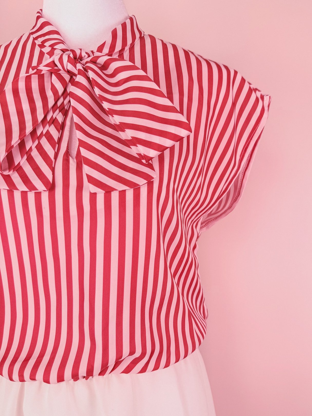 Red and white striped dress featuring a bow tie neckline and short cap sleeves, reflecting 1970s style.