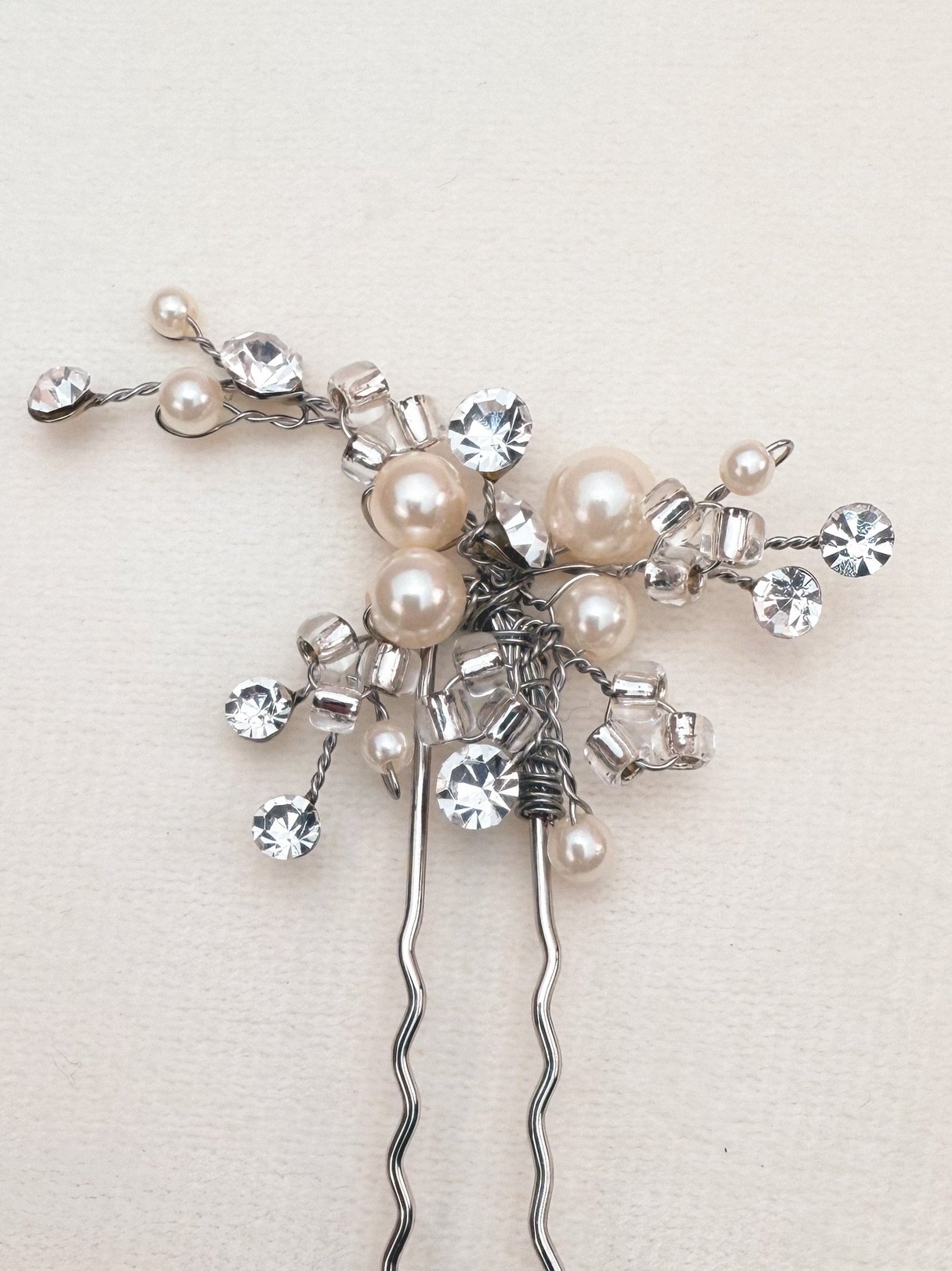 Silver hair pin featuring sparkling crystals and pearls, designed for women's accessories and inspired by the 1970s.
