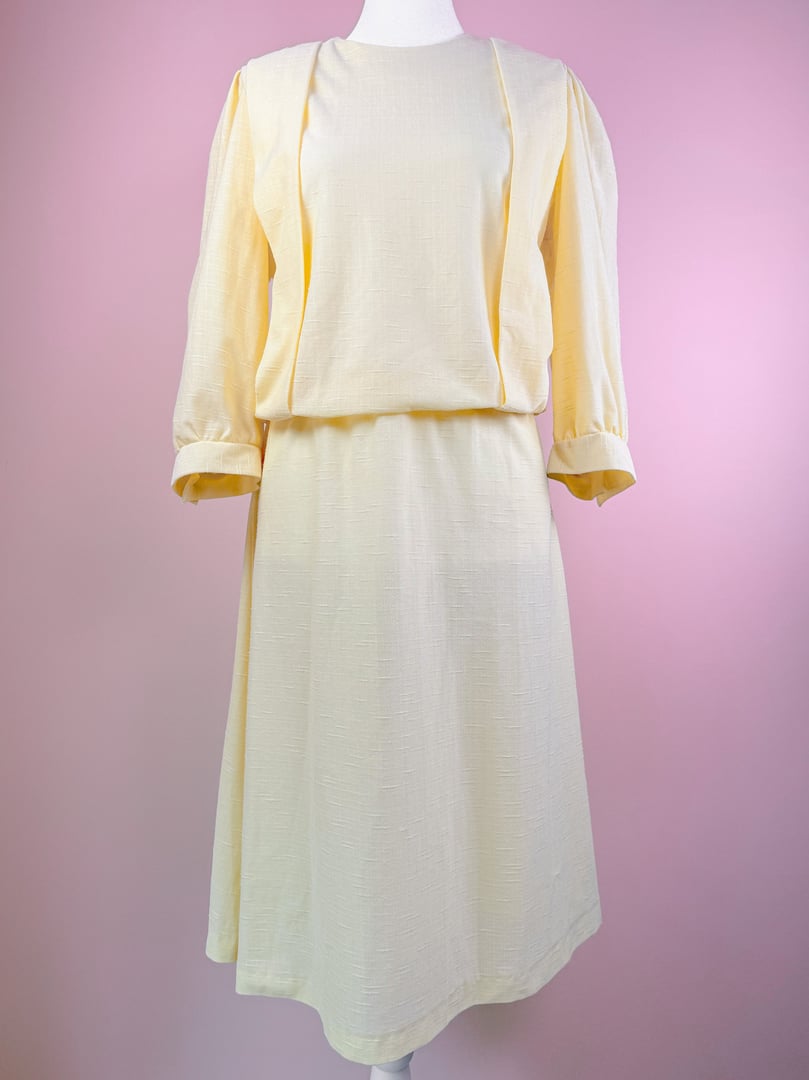 A pastel yellow Lemon Chiffon Dress with a relaxed fit and three-quarter sleeves, showcasing a 1980s style.