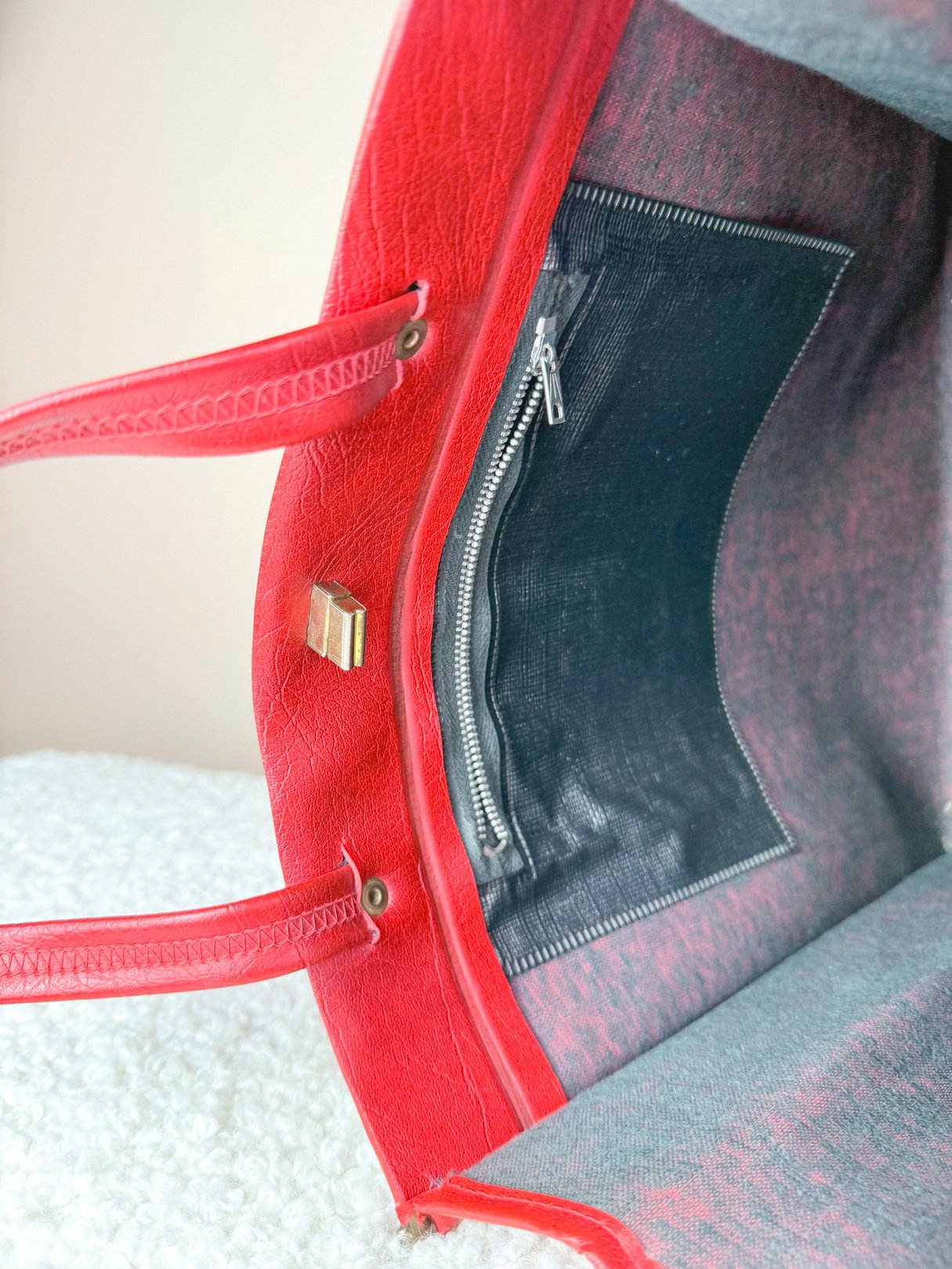 Interior view of a red tote bag featuring a zippered pocket and dual shoulder straps, designed for women in a 1970s retro style.