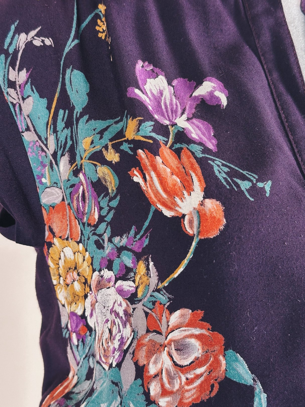 Purple 1970s women's dress featuring vibrant floral embroidery in various colors.
