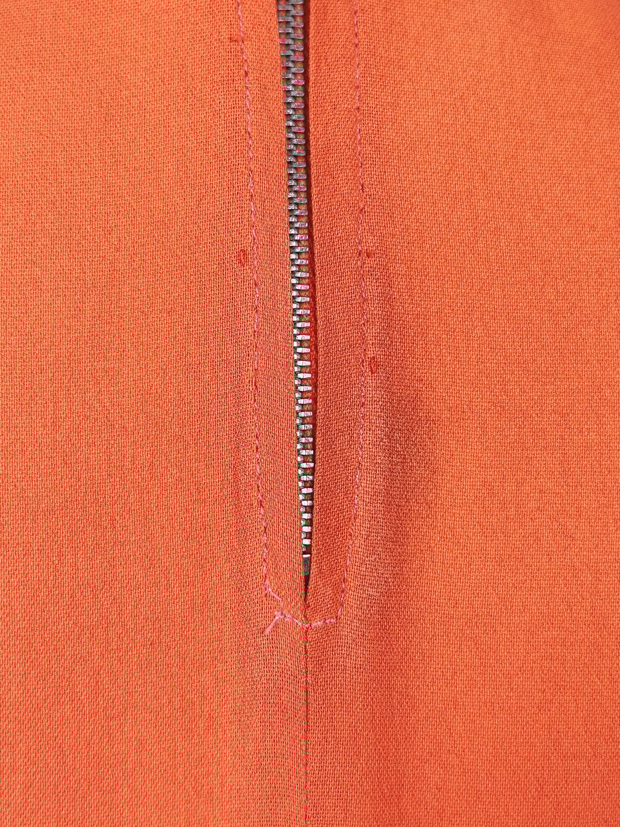 Coral fabric featuring a zipper detail, reflecting the style of 1940s women's dresses.