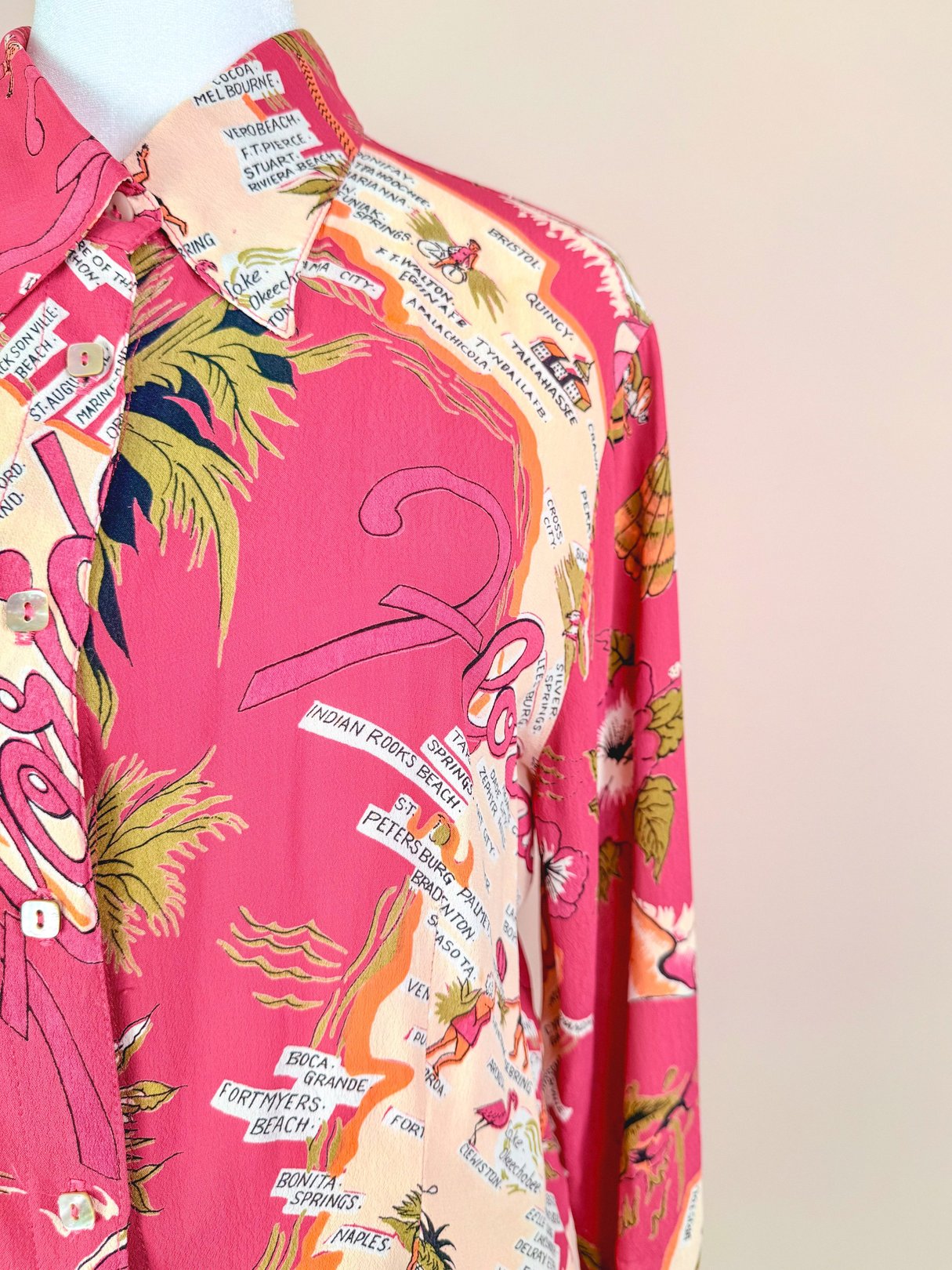 1970s women's white top featuring a colorful Florida-themed print with palm trees and city names.