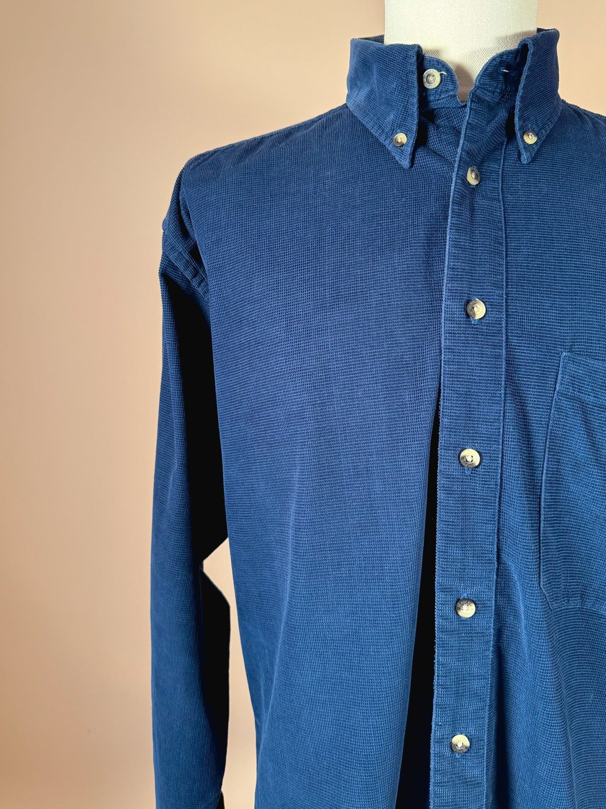 Navy blue men's cord shirt from the 1990s featuring a button-down collar and a front pocket.