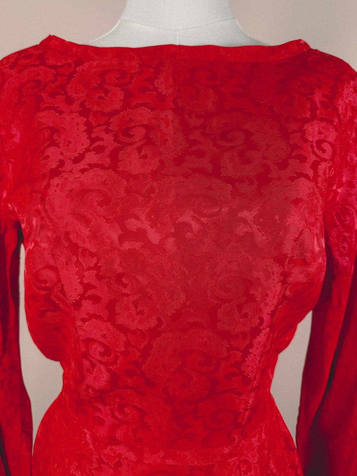 Red damask dress for women featuring a textured pattern, representative of the 1950s era.