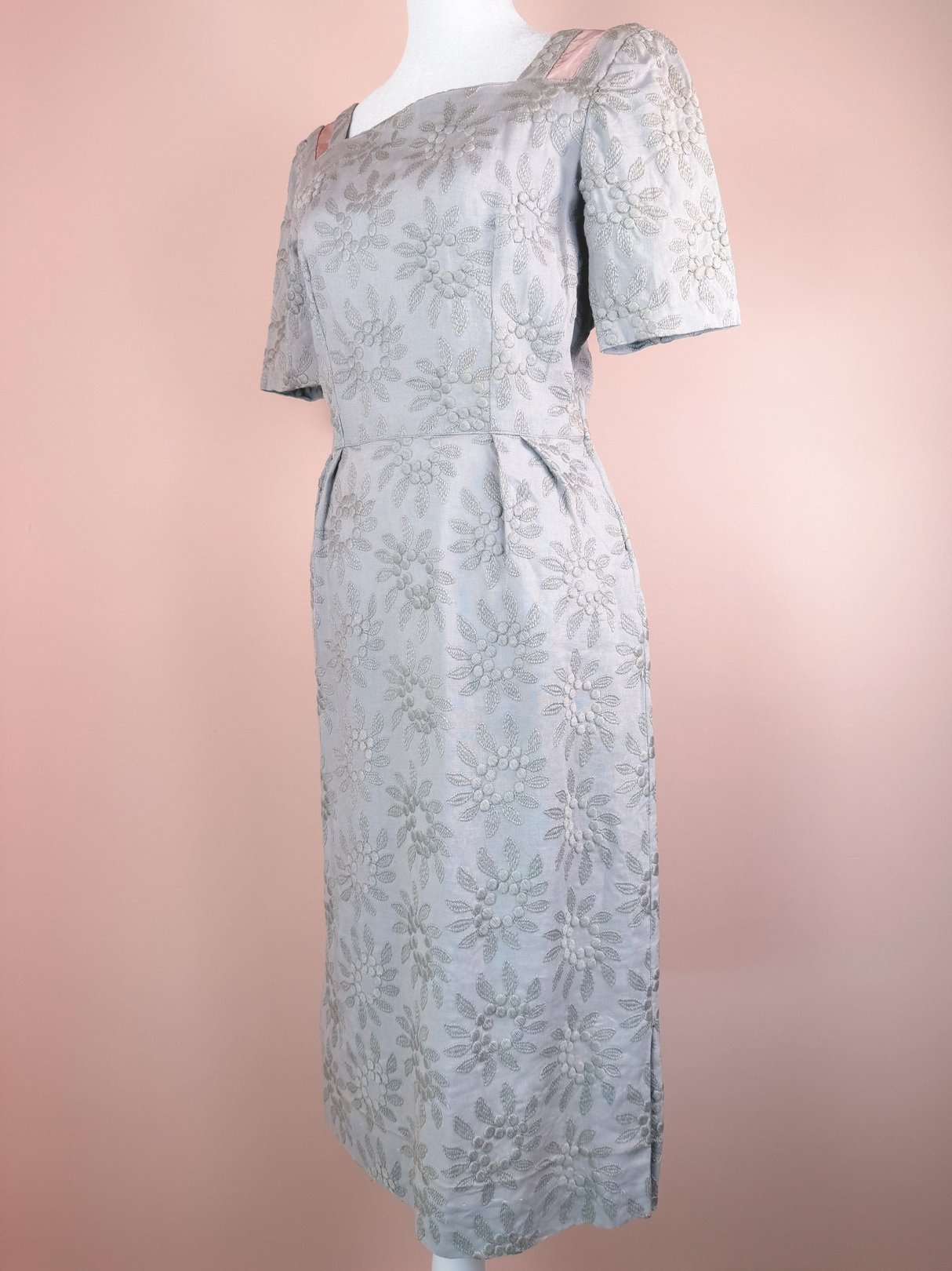 Slate blue 1950s women's dress with short sleeves, floral patterns, and a fitted silhouette.