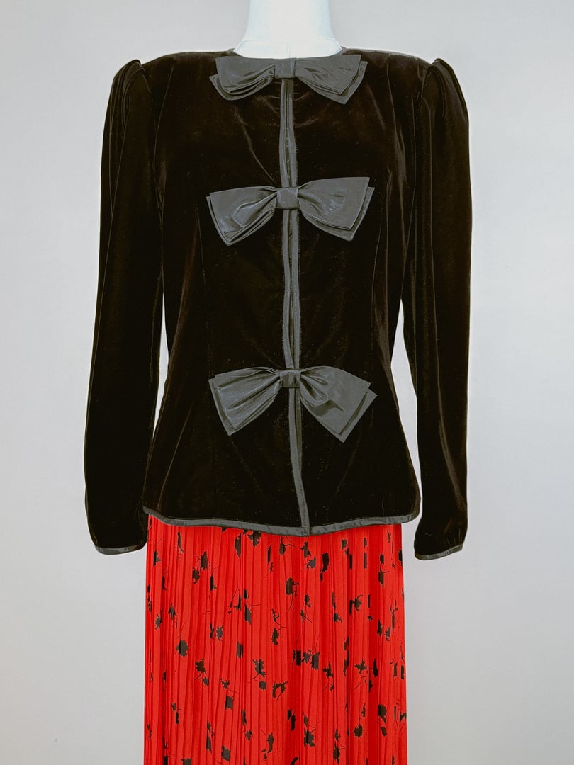 Black velvet 1980s women's jacket featuring three bows on the front and puffed sleeves.