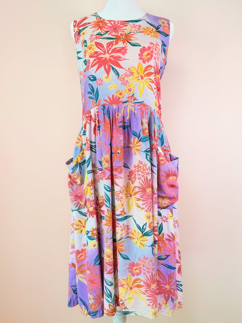 A pink and floral patterned summer dress from the 1990s featuring a sleeveless design and side pockets.