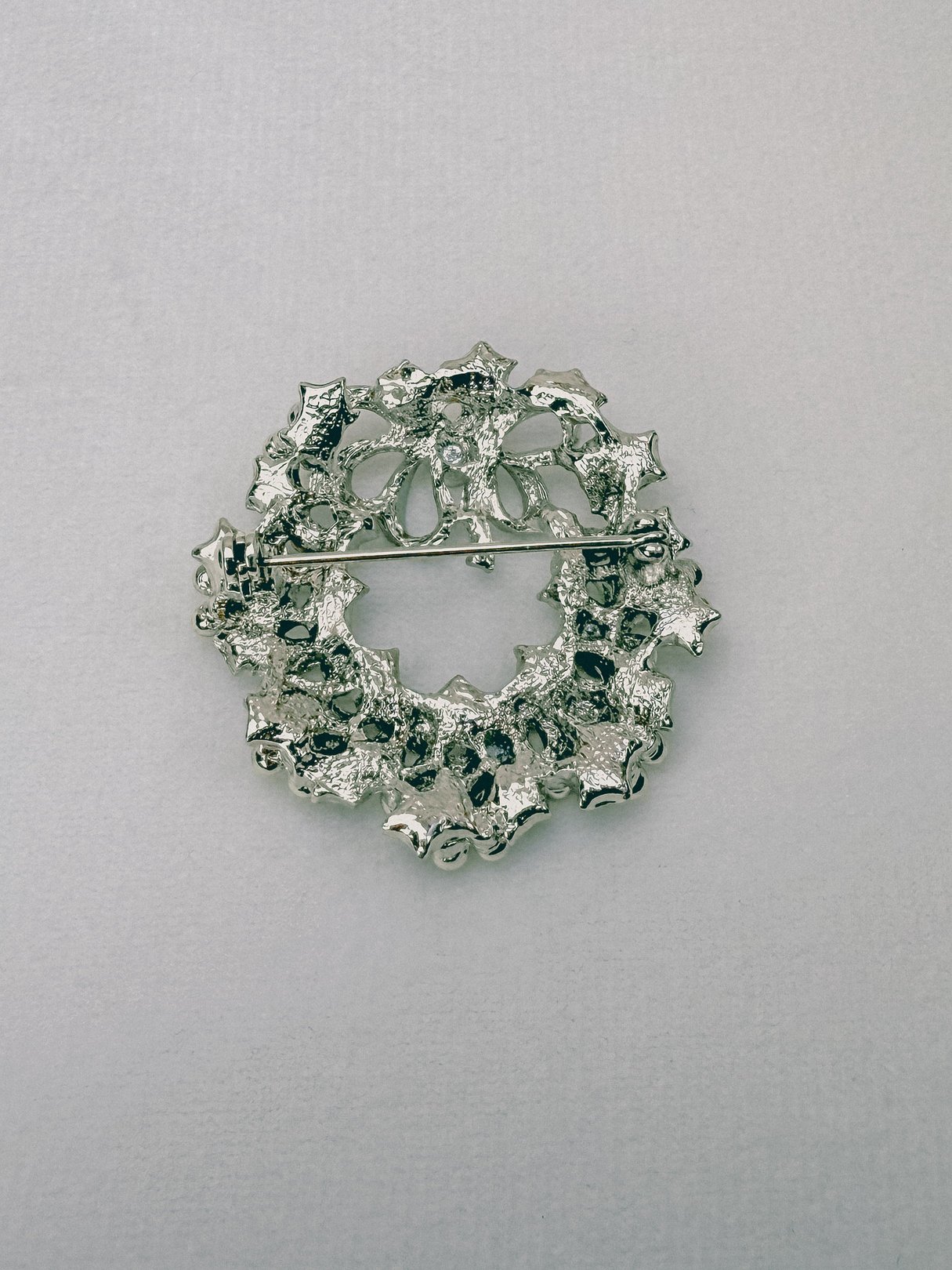 Silver 1970s keepsake wreath brooch designed for women, featuring a decorative floral and leaf motif.
