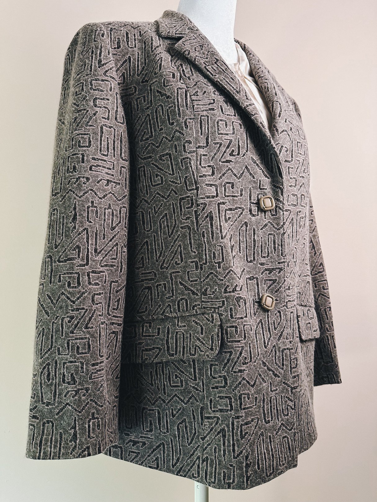 Pink geometric patterned blazer for women, featuring double-button closure and a structured silhouette, inspired by 1980s fashion.