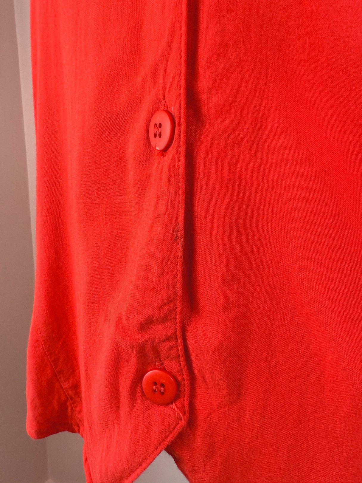 Red 1980s women's top featuring button details on the side.