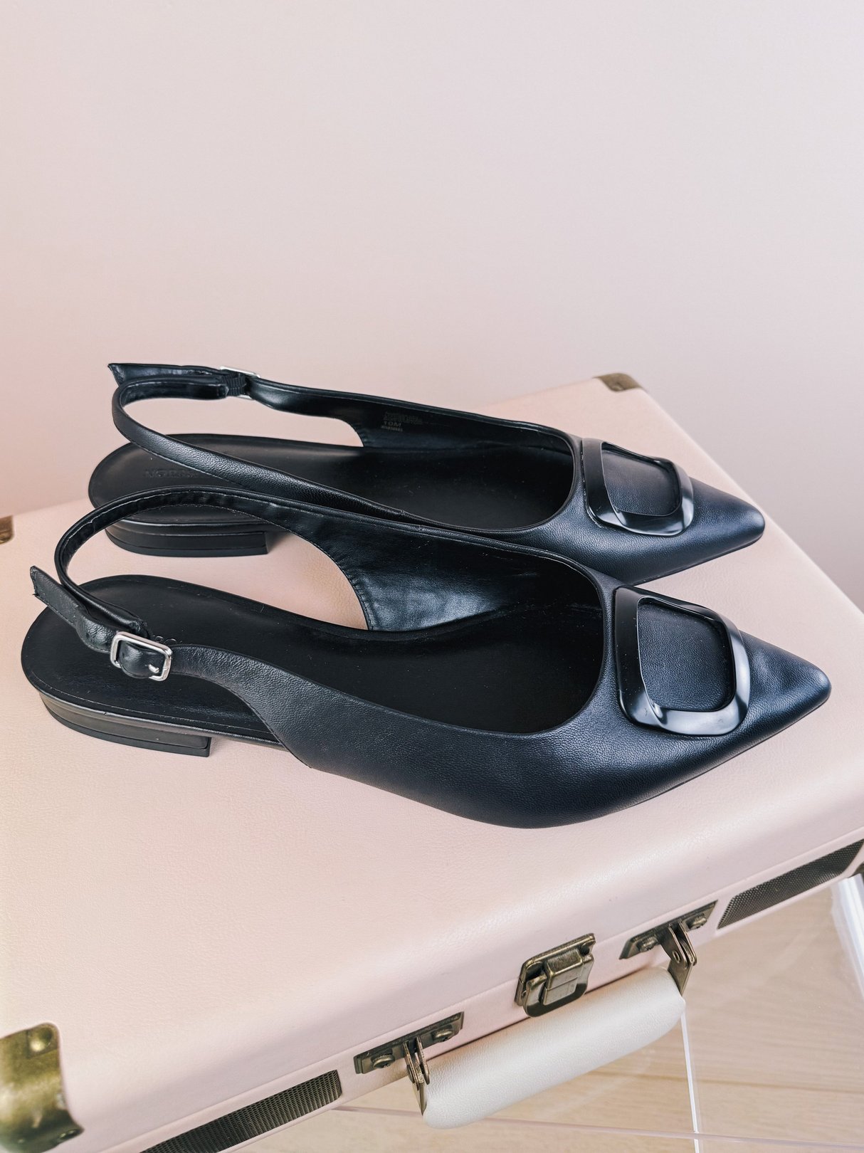Black 1960s women's slingback flats featuring a square toe and a buckle detail.