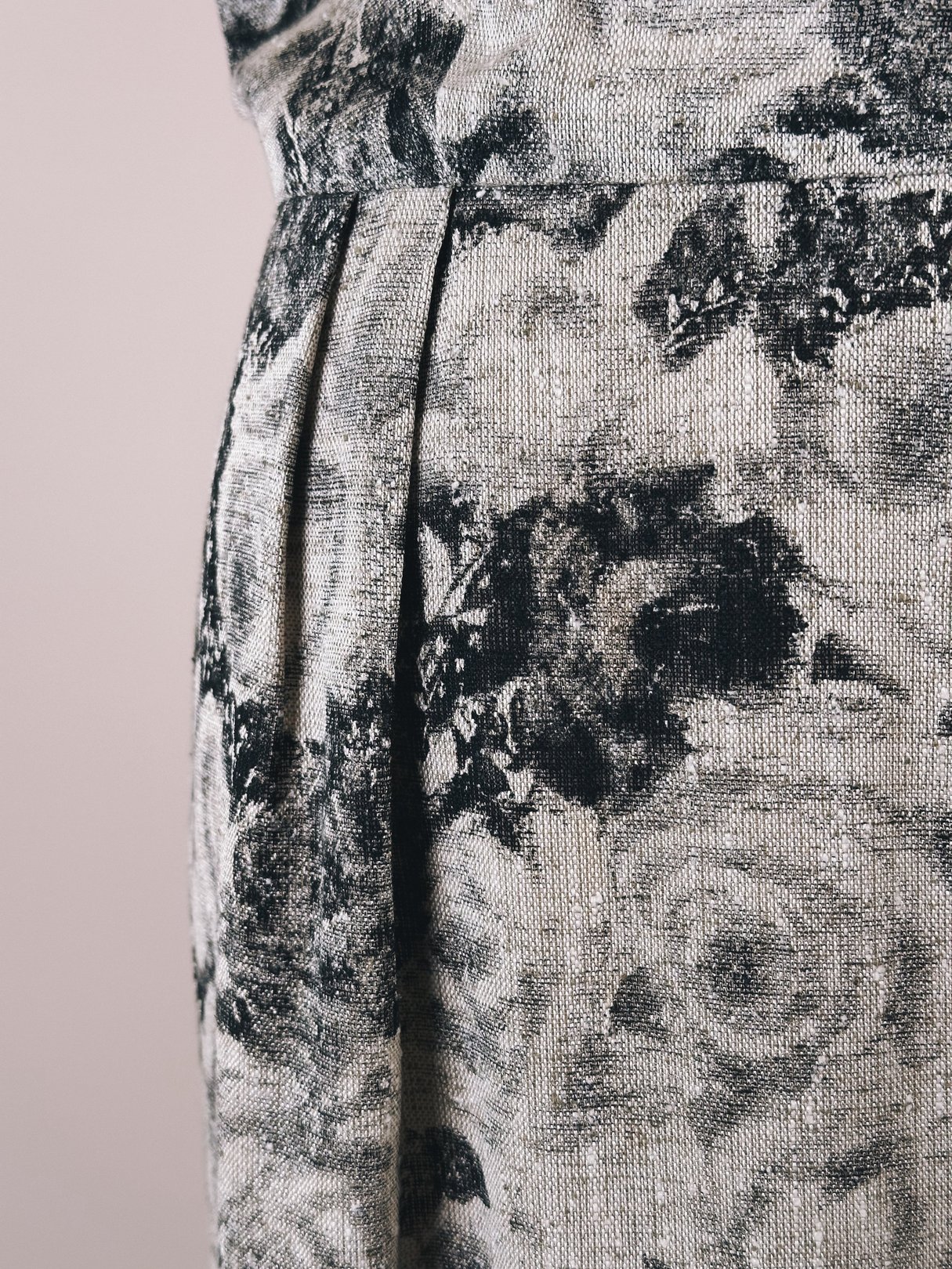Close-up of a women's black and cream dress featuring a floral rose pattern, styled in a 1950s design.