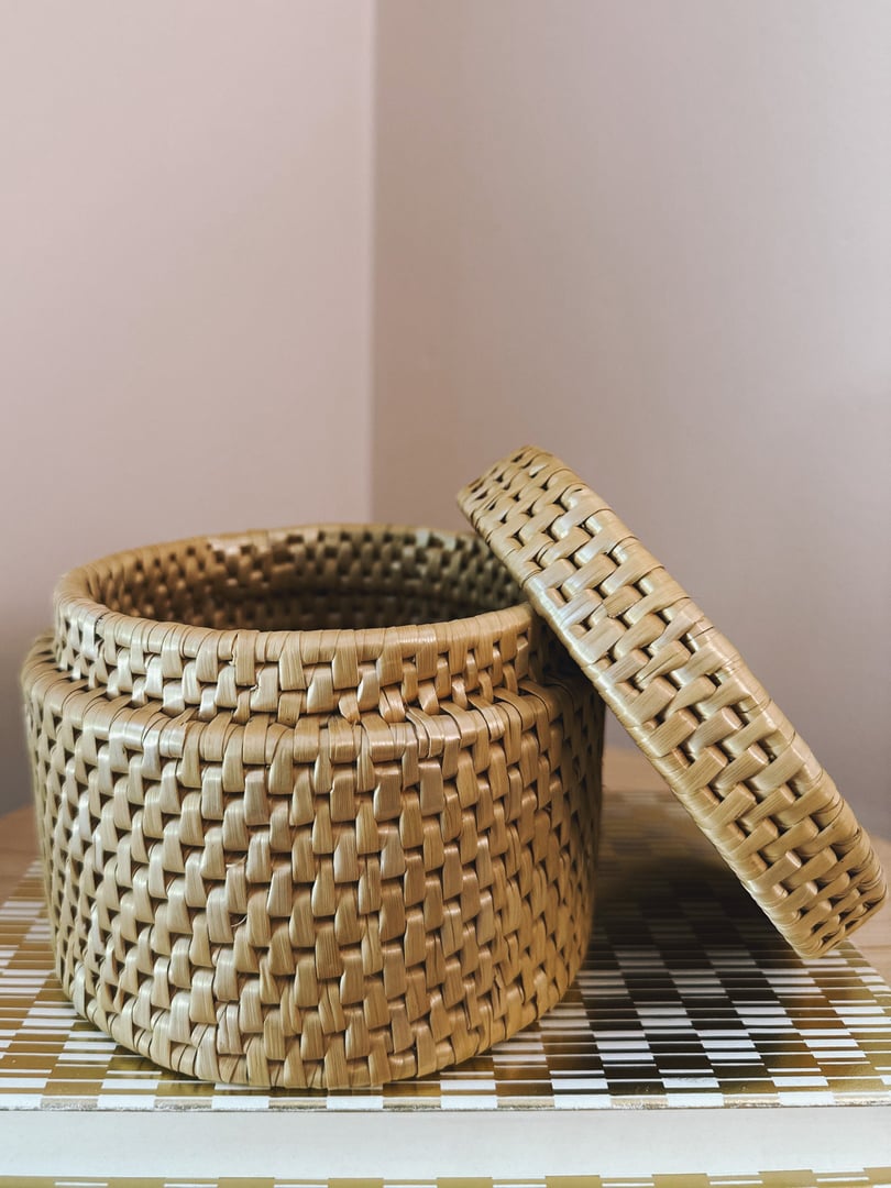 Round woven trinket basket with a lid, featuring a geometric pattern in light brown, reflecting a 1970s design aesthetic.