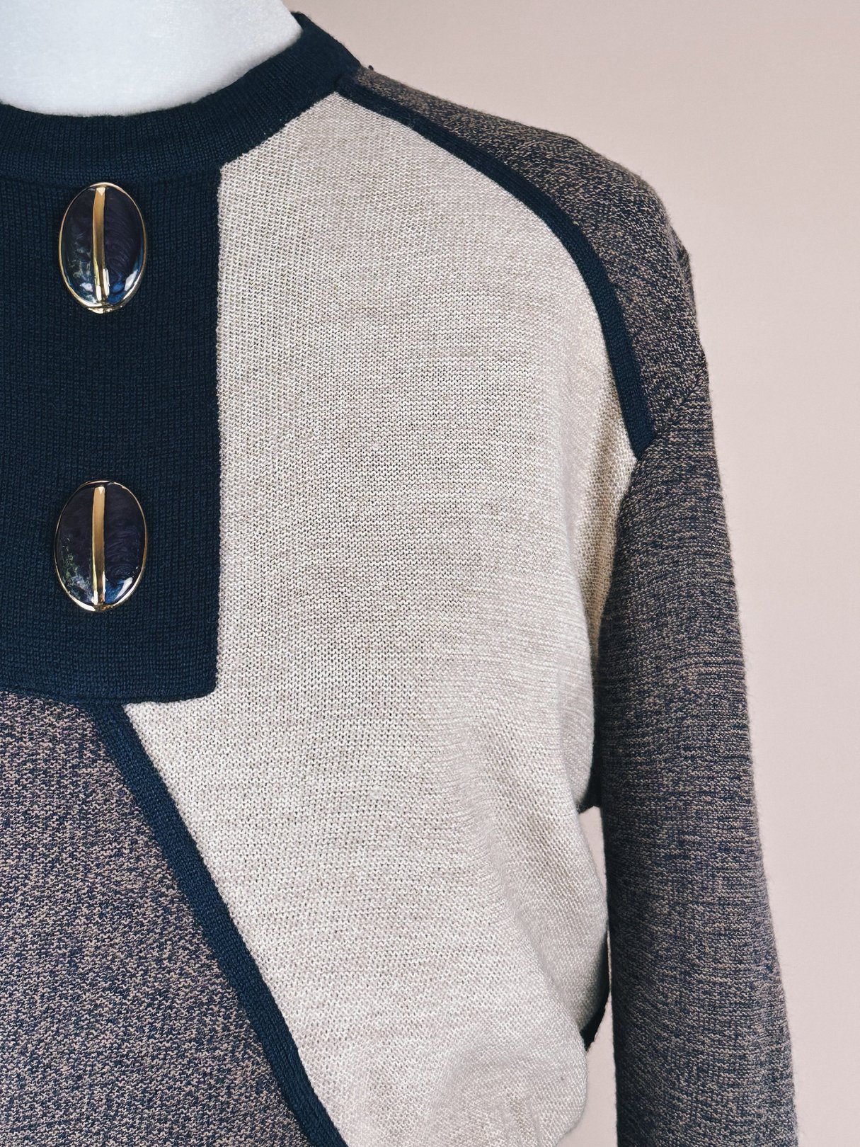 Navy blue 1980s artist sweater dress featuring contrasting textured fabric and two decorative buttons on the shoulder.