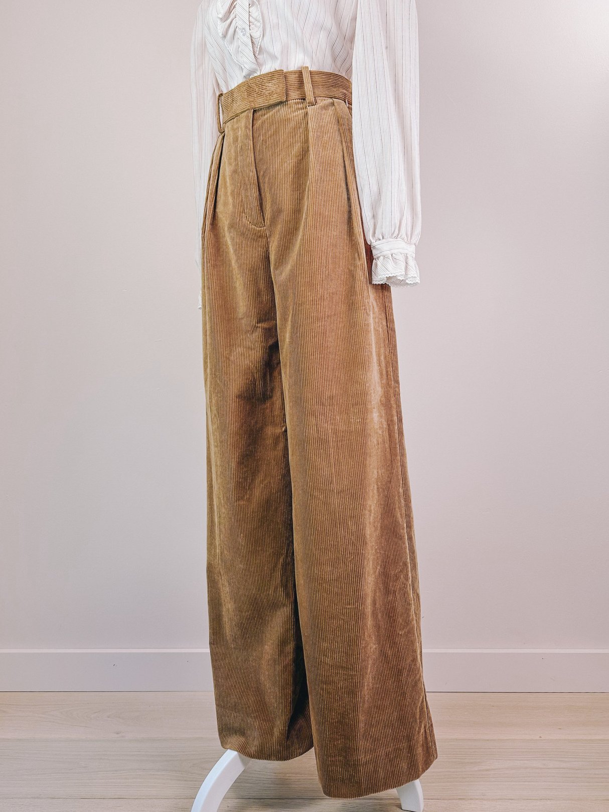 High-waisted, wide-leg corduroy pants in toast brown, designed for women, reflecting a 1970s style.