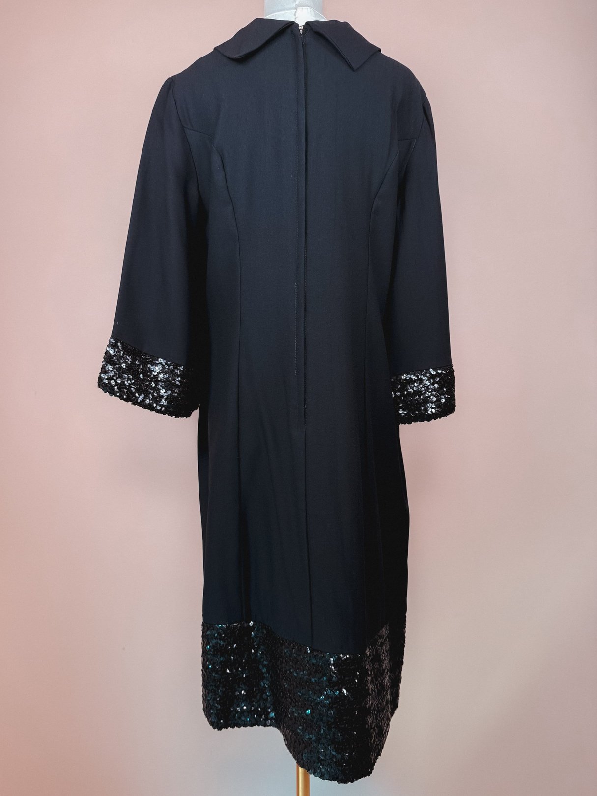 Black 1960s Mod Sparkle Dress featuring sequin embellishments on the sleeves and hemline.