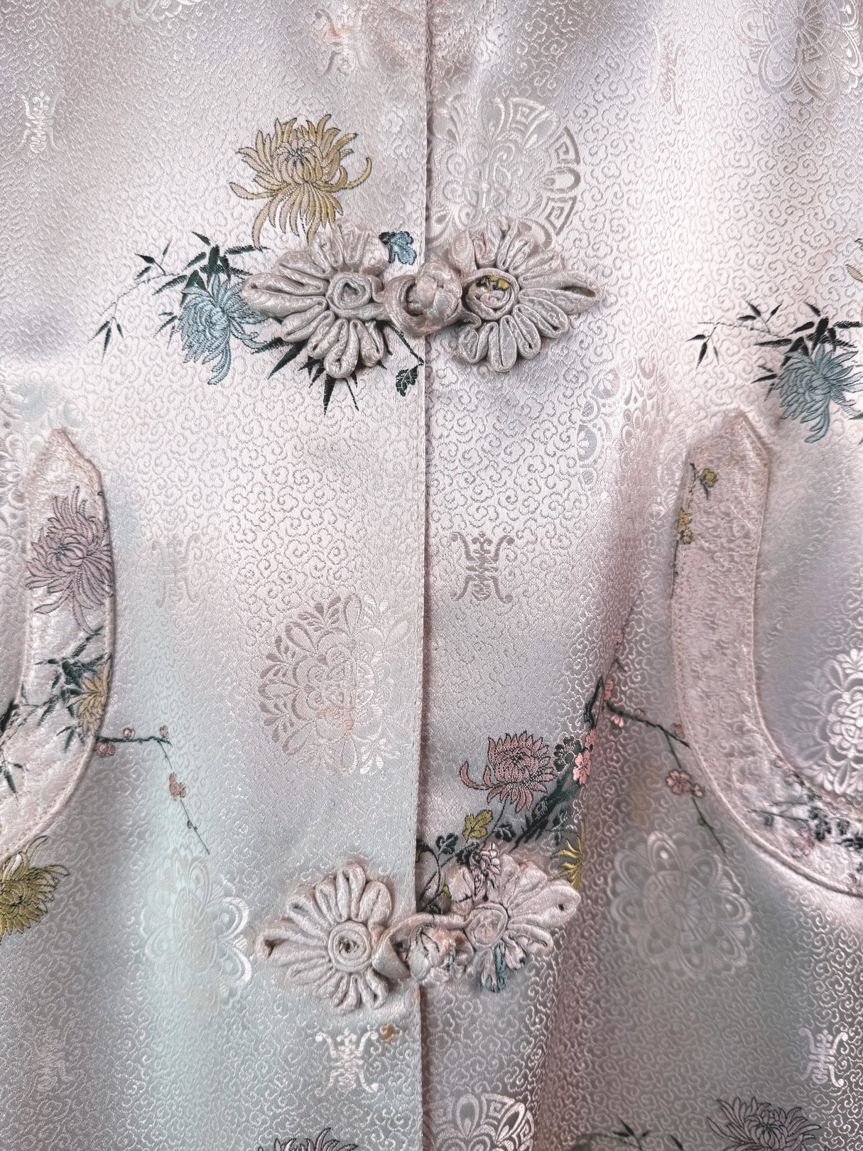 Silver 1970s women's Harmony Silk Cheongsam coat featuring floral embroidery and decorative front buttons.