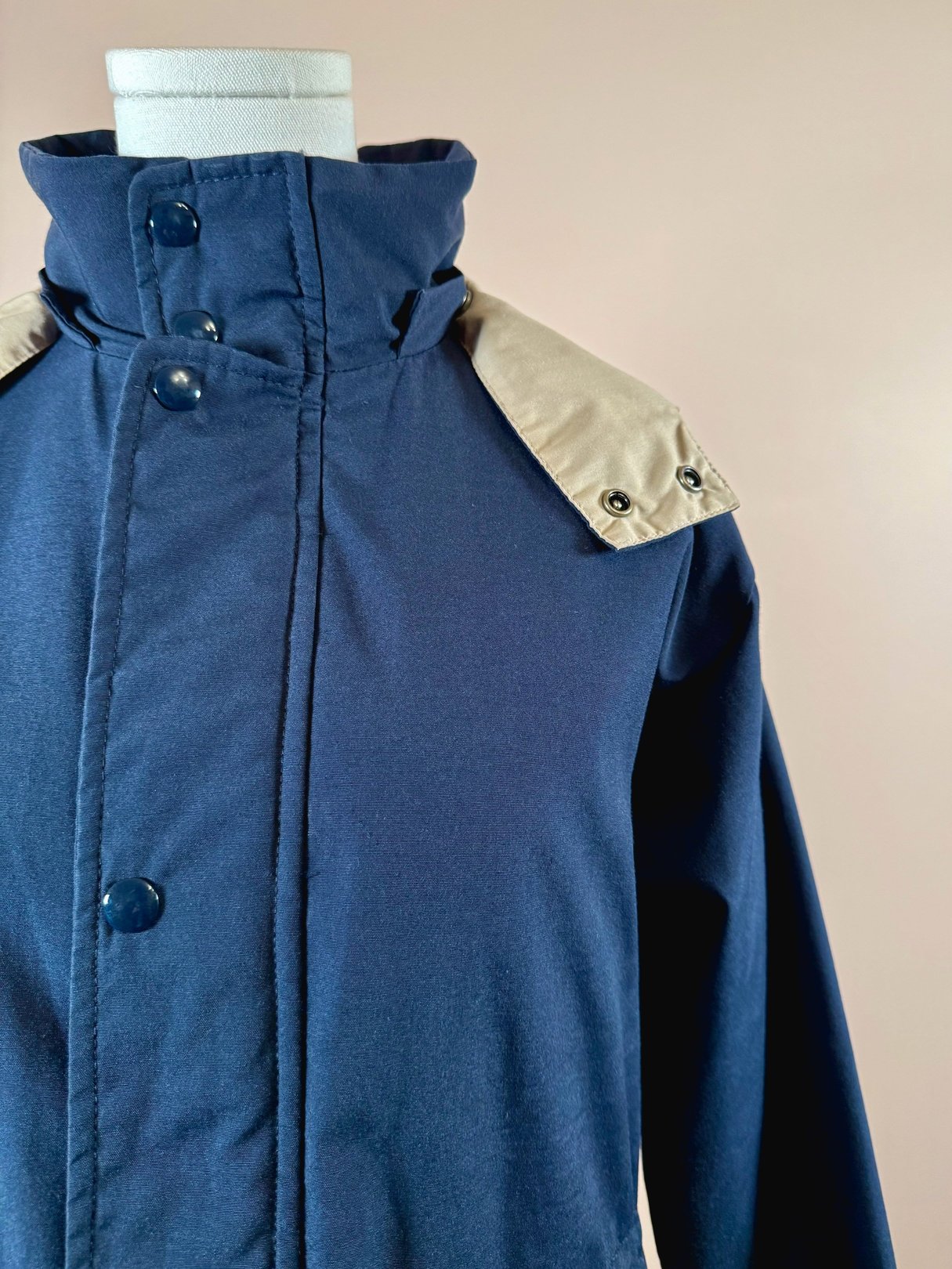 Navy blue 1970s women’s utility field coat featuring a beige collar and button details.
