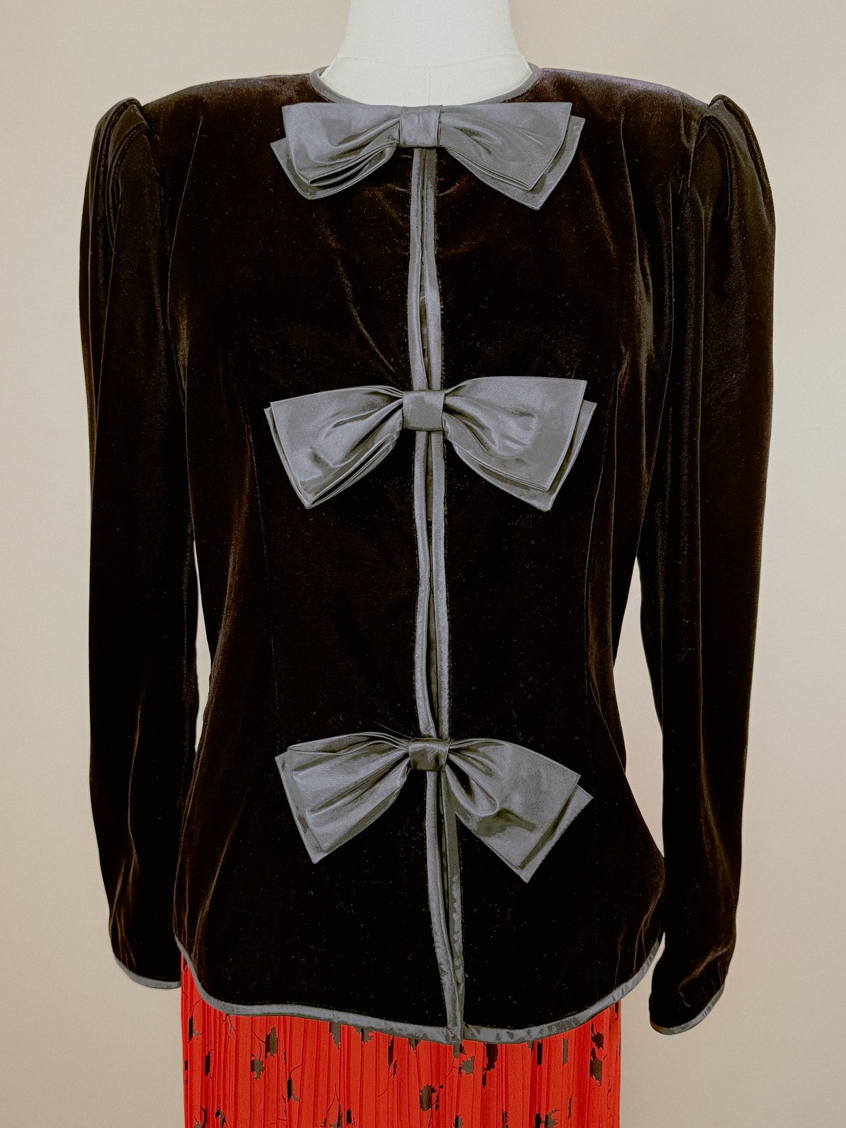 Black velvet women's jacket from the 1980s featuring three decorative gray bows on the front.
