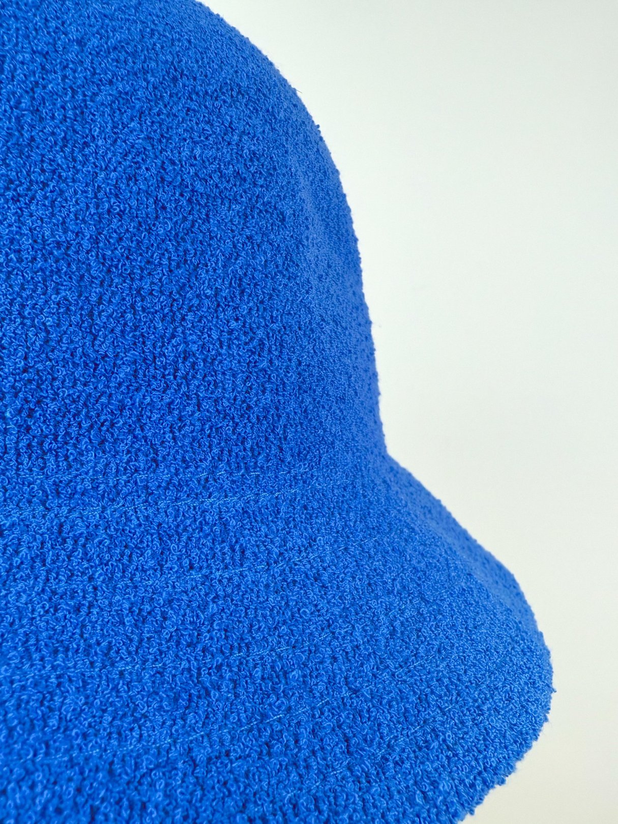 Cobalt blue bucket hat with a textured surface, designed for women and inspired by 1960s fashion.