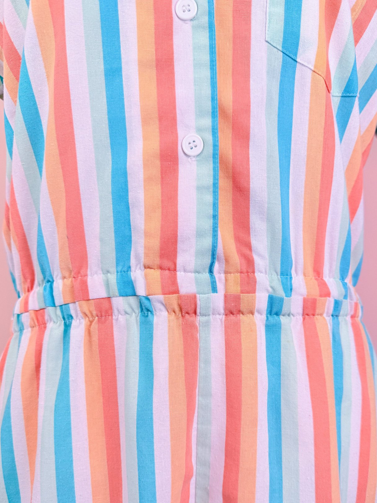 Women's 1980s Club Cabana Romper featuring a blue, pink, and white striped pattern with a button-down front and elastic waistband.