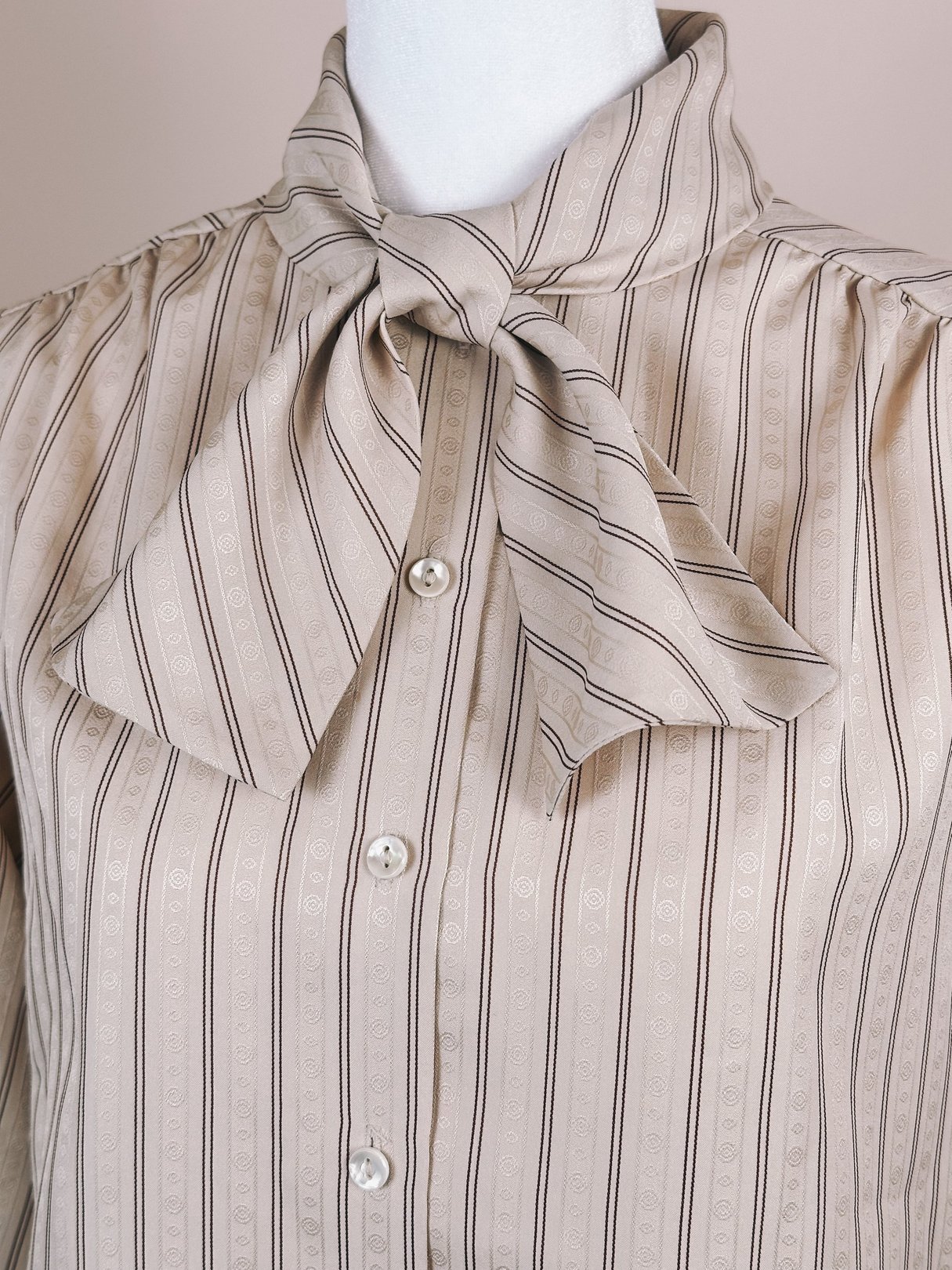 Maroon striped blouse with a bow tie collar and button-down front.