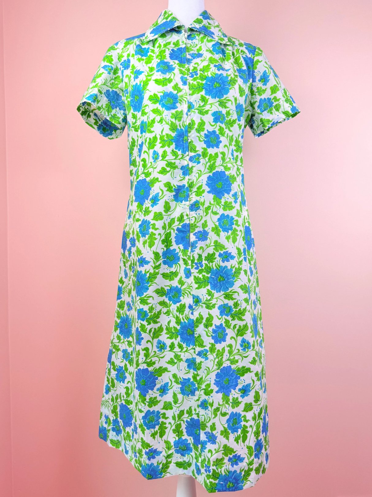 Floral dress with blue and green flowers on a white background, featuring a collared neckline and short sleeves.