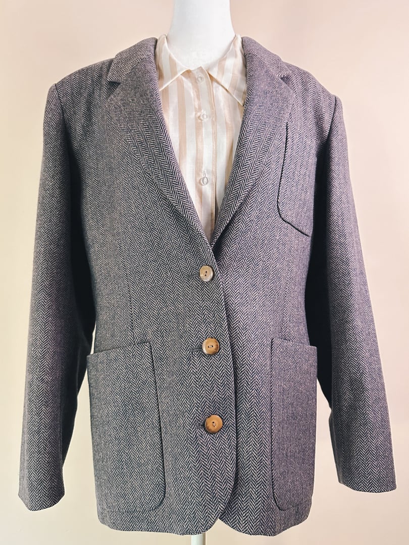 Mauve pink women's tweed blazer from the 1970s featuring a notch lapel, three buttons, and two front pockets.
