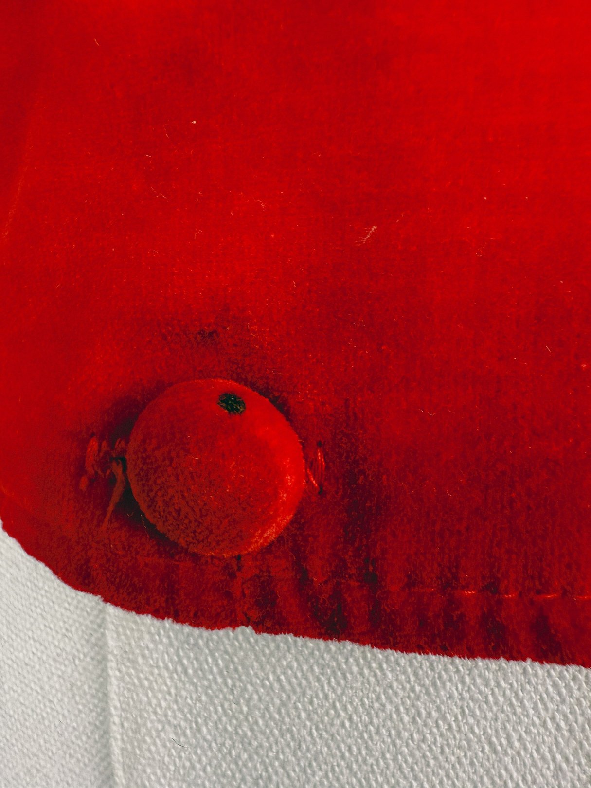 Red velvet vest featuring a prominent red fabric-covered button, reflecting a 1970s style.