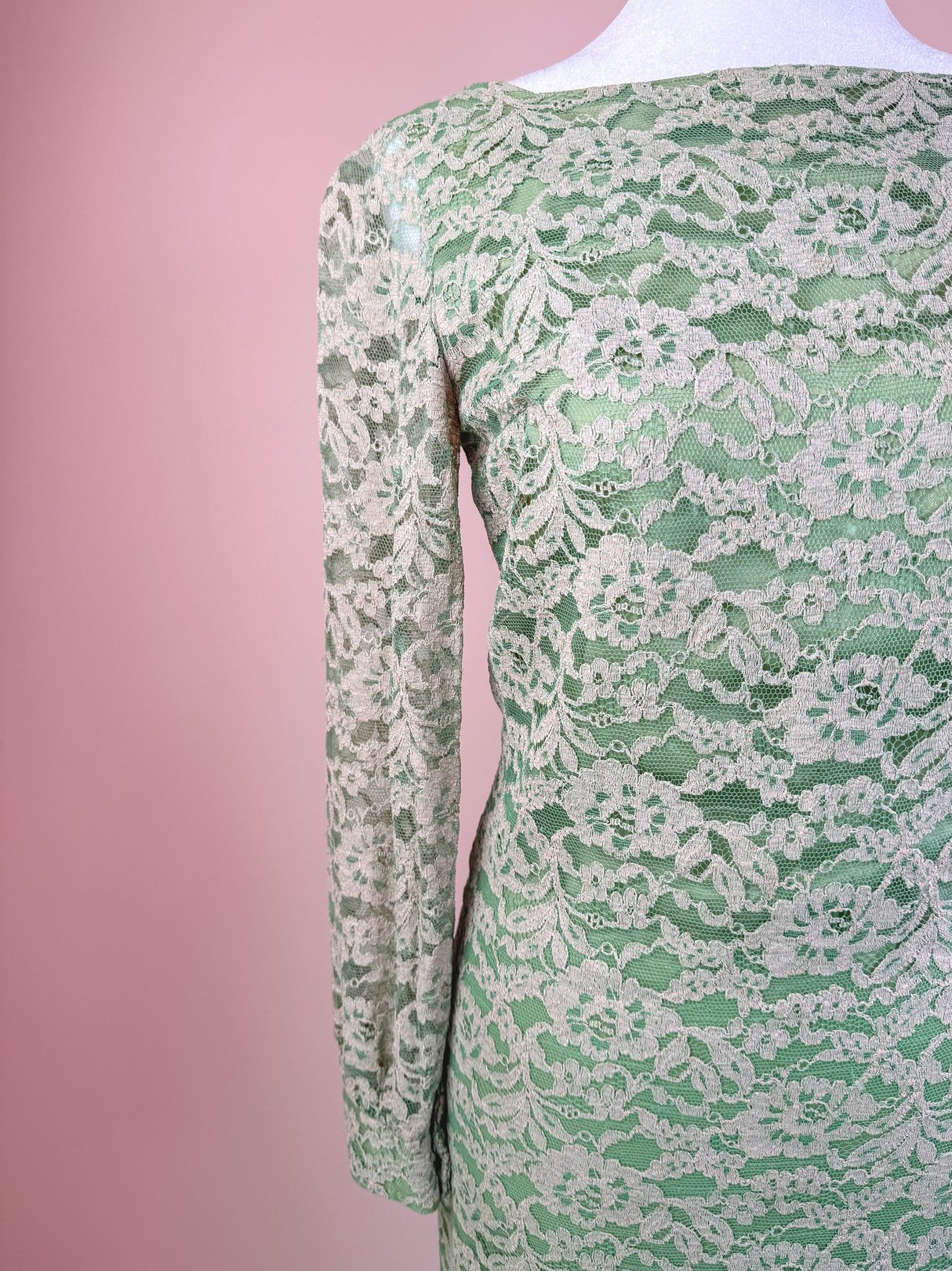 A seafoam green 1960s women's dress featuring intricate lace detailing and long sleeves.