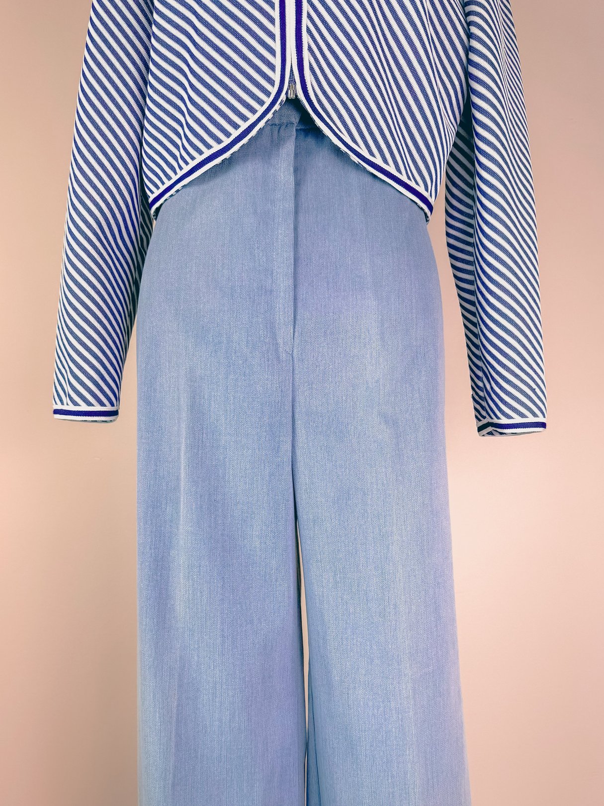 Light blue 1970s women's pants with a wide-leg design, styled with a striped jacket.