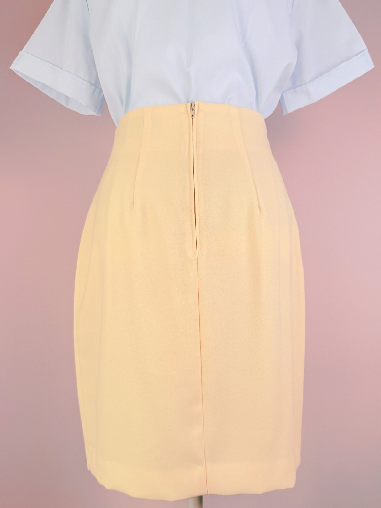 Buttery yellow 1990s women's skirt with a back zipper and subtle pleats.