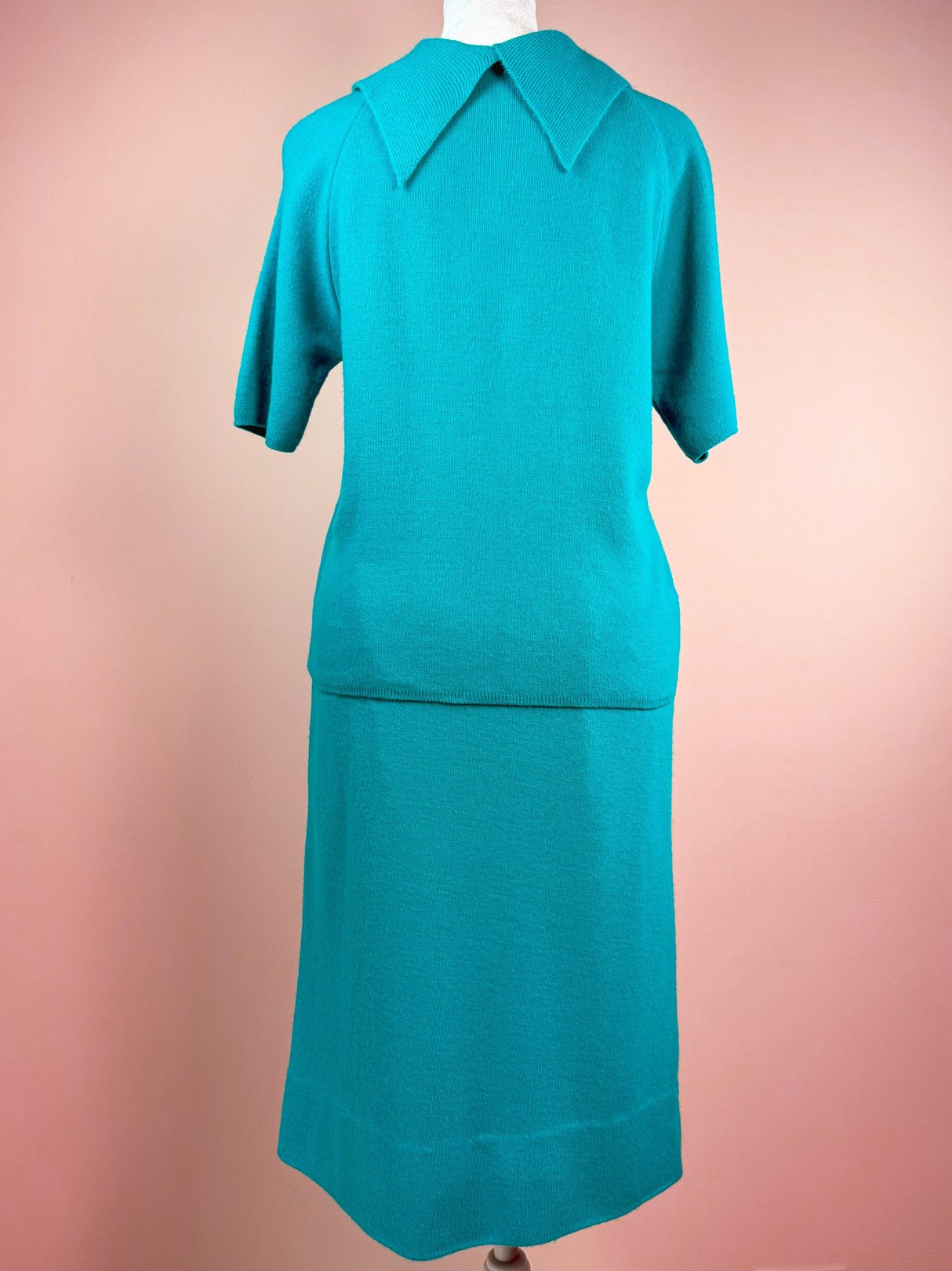 Teal green 1960s women's knit skirt set featuring a short-sleeve top with a collar and a knee-length skirt.