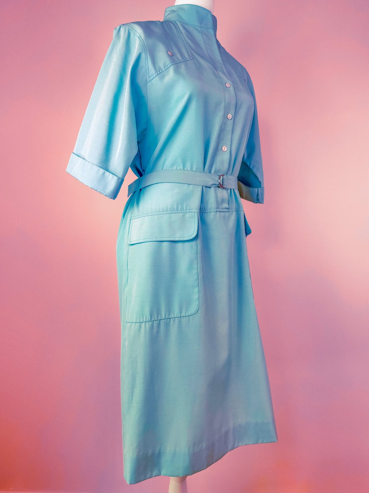 Sky blue 1960s women's shift dress featuring short sleeves, a collared neckline, and a belted waist with side pockets.
