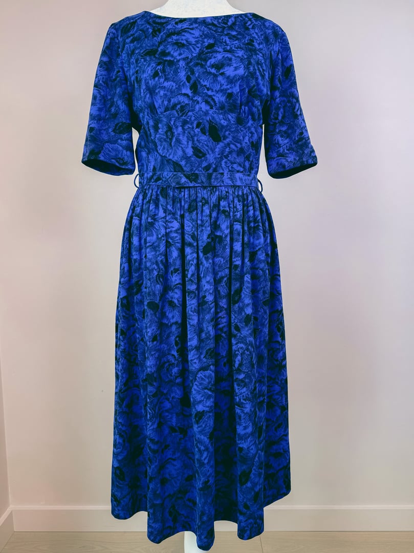 Midnight blue 1960s women's dress featuring a floral pattern and a gathered waist.