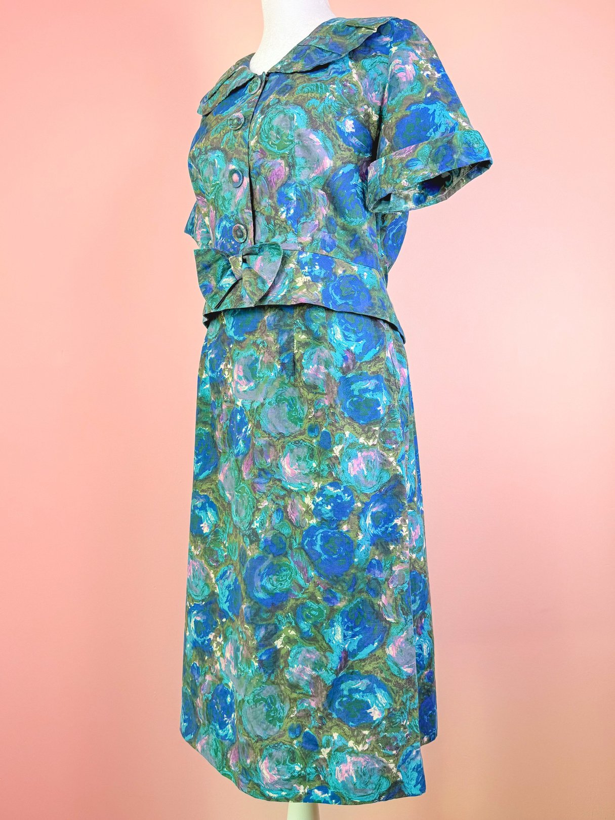 Blue 1950s-style skirt set featuring a patterned top with a bow detail and short sleeves.