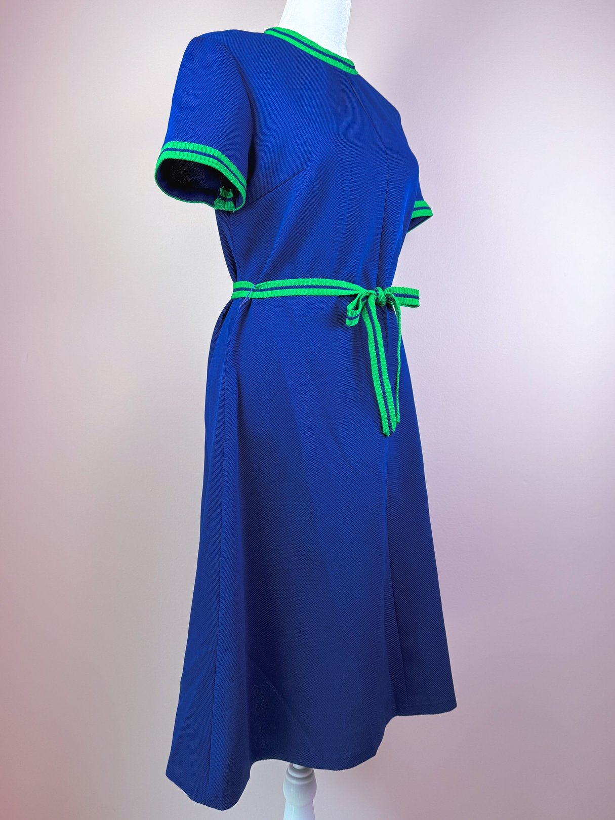 1970s women's blue dress with green trim and a matching belt.