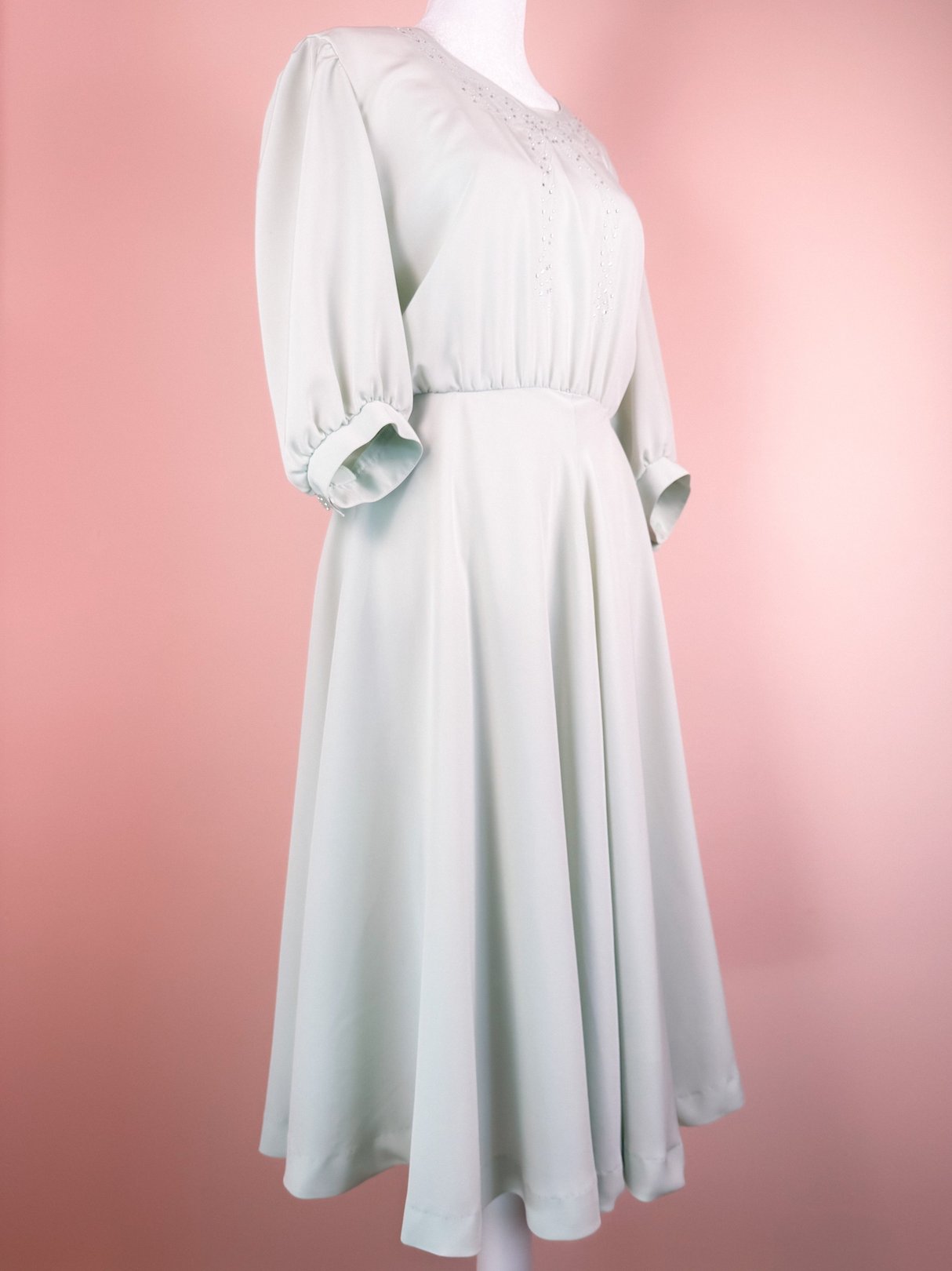 Mint green 1980s women's dress with a flared skirt and short puff sleeves.