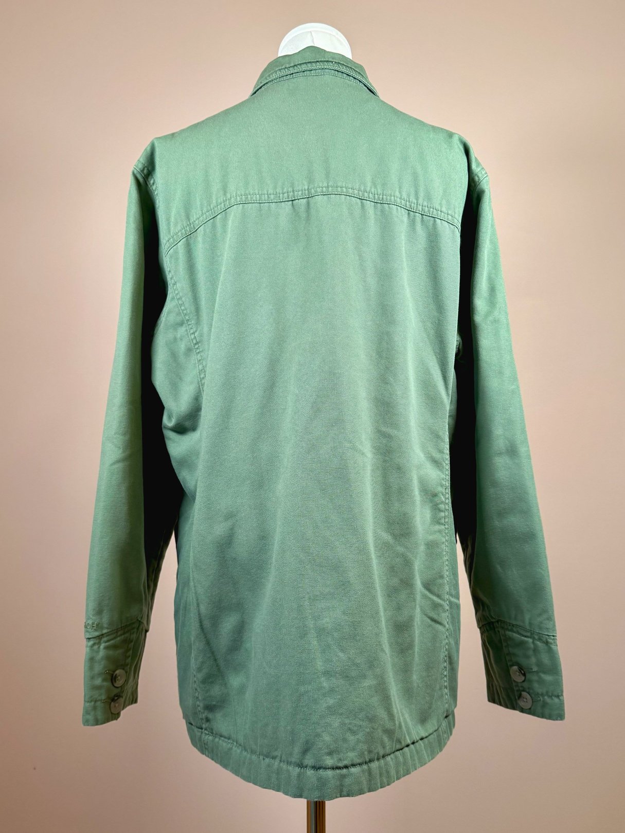 Sage 1970s women's quilted jacket with a simple back design and buttoned cuff details.