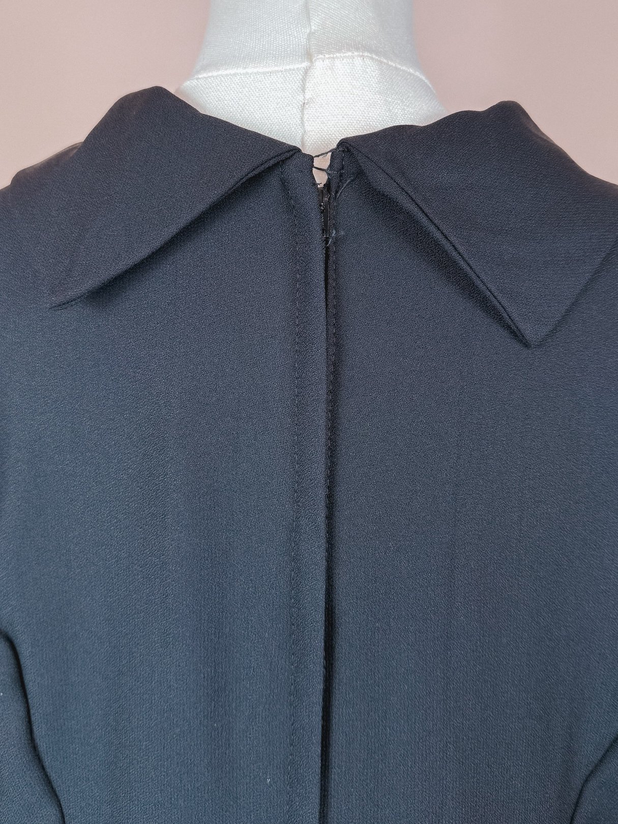 The Mod Sparkle Dress features a black fabric with a large collar and a concealed back zipper, embodying the style of the 1960s for women.