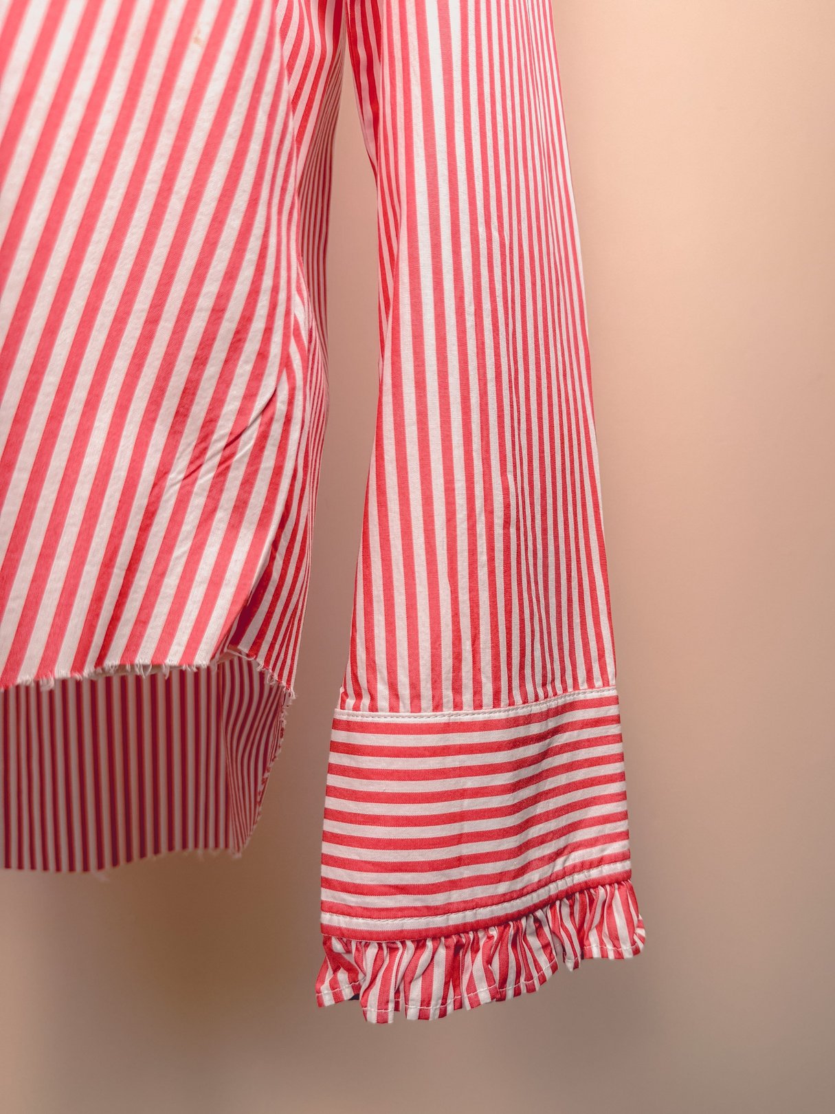 Red and white striped 1970s women's button down top with ruffled sleeve cuffs.
