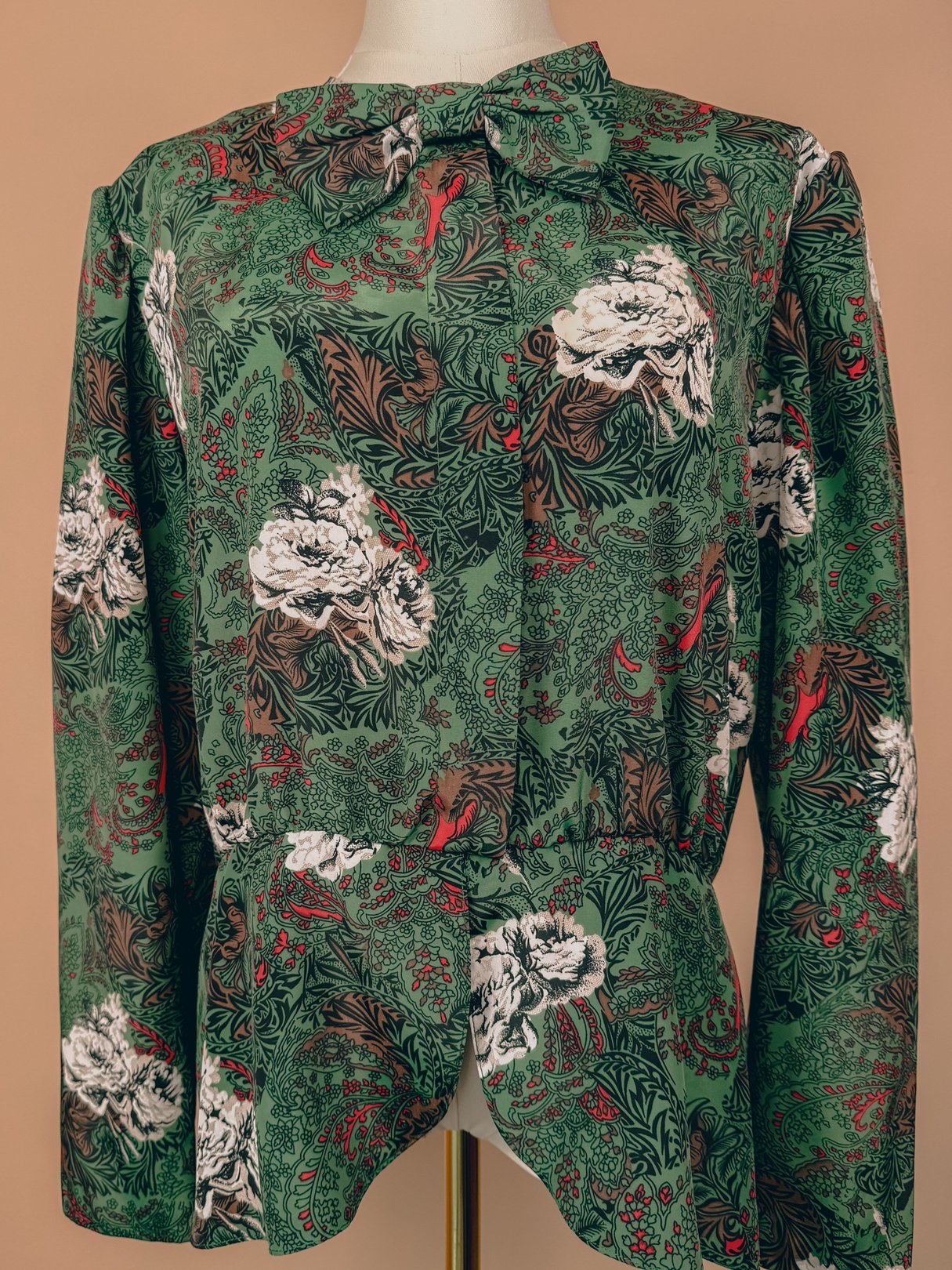 Red bow-topped women's top from the 1980s, featuring a floral and foliage print.