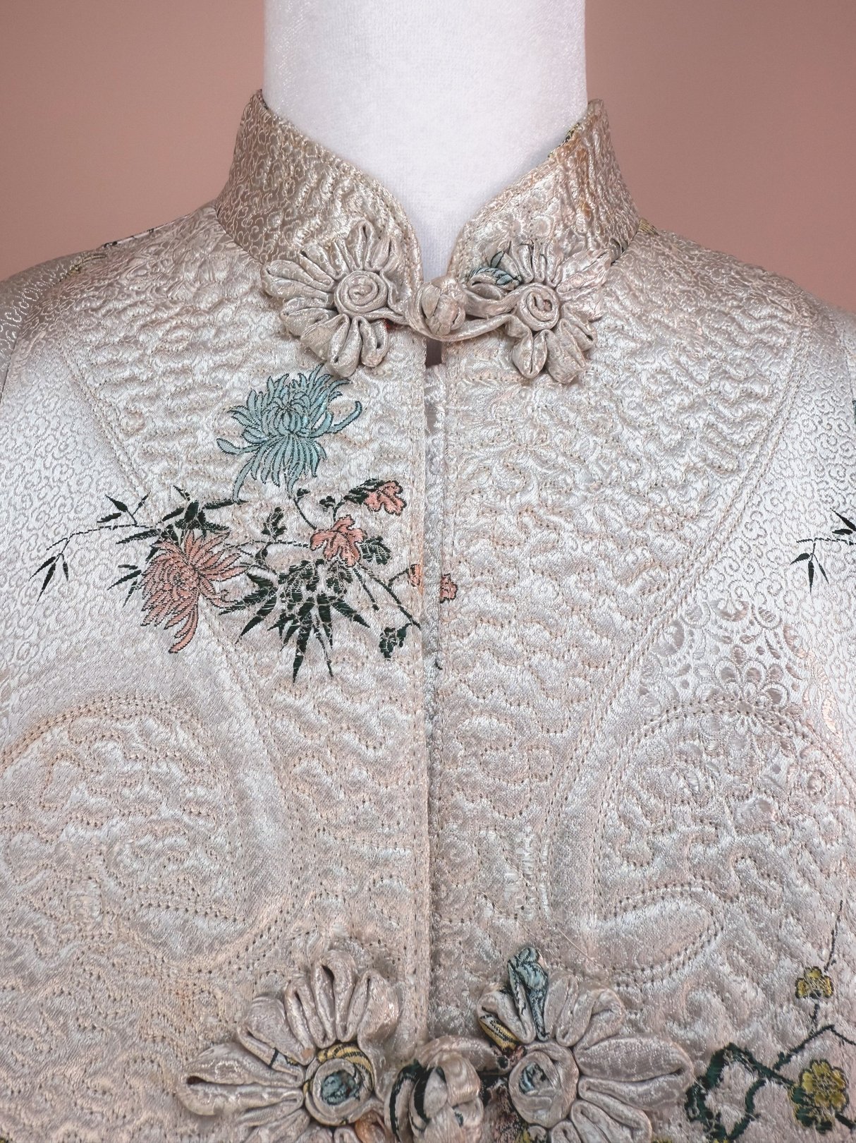 1970s women's Harmony Silk Cheongsam Coat in silver with floral embroidery and decorative buttons.