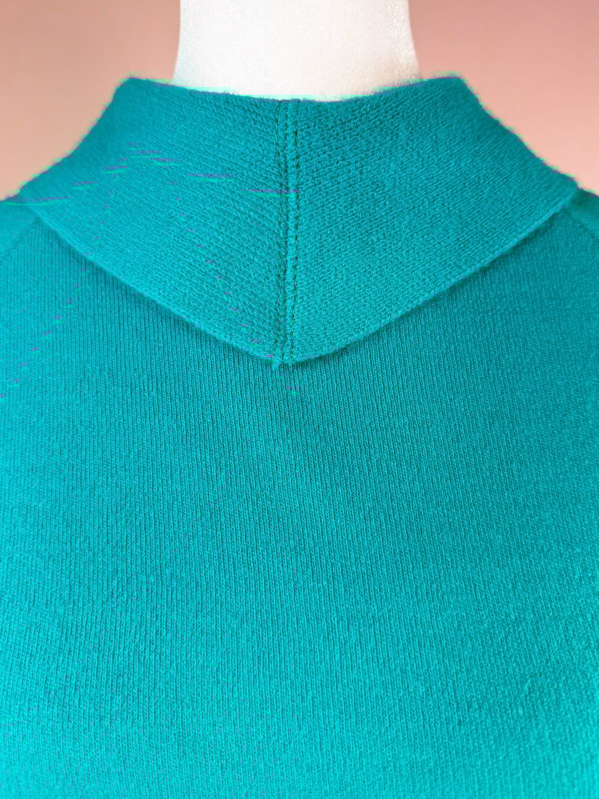 Teal green knit top with a hooded neckline, designed for women's 1960s skirt set.