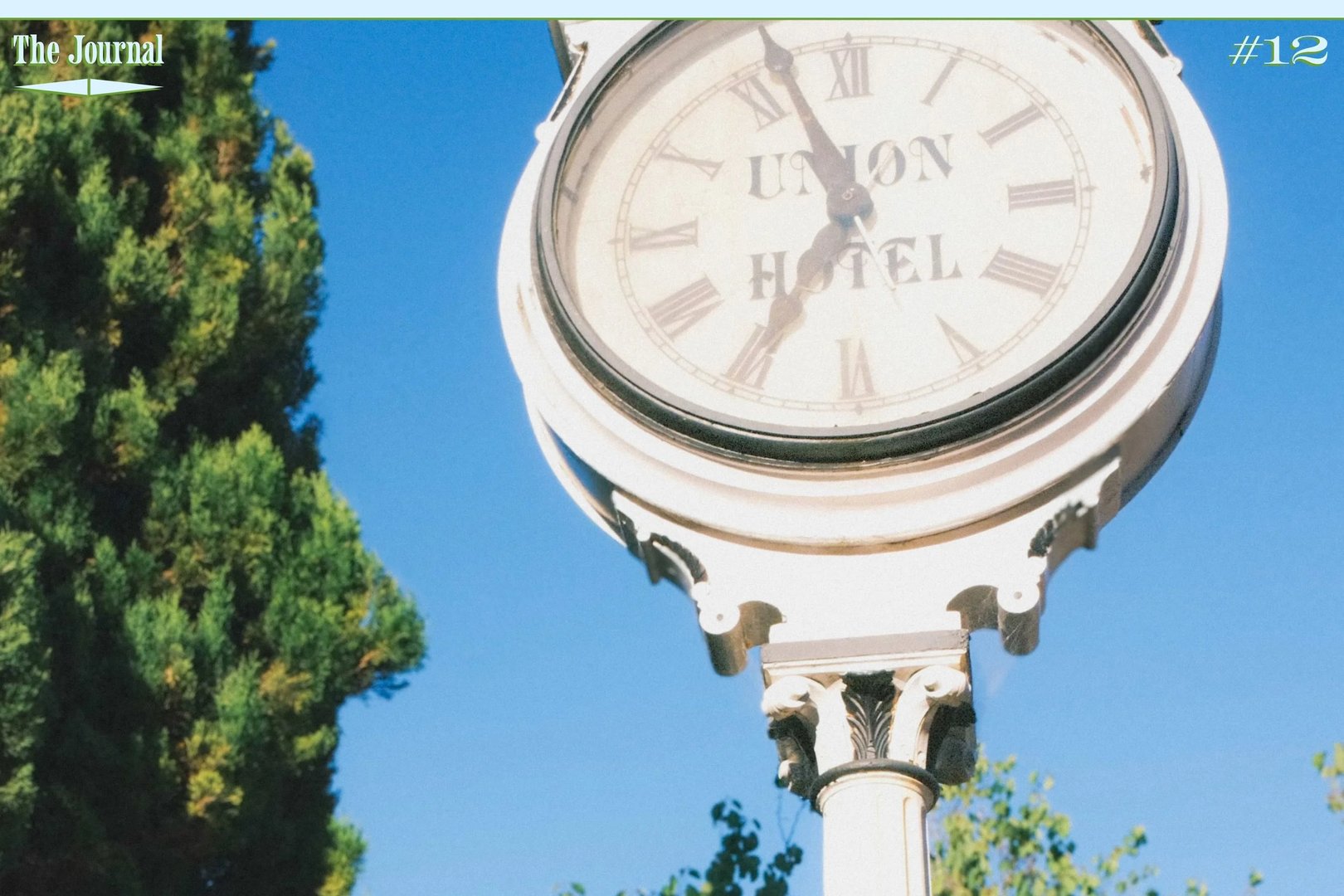 A vintage clock at Union Hotel, surrounded by trees and a clear blue sky.