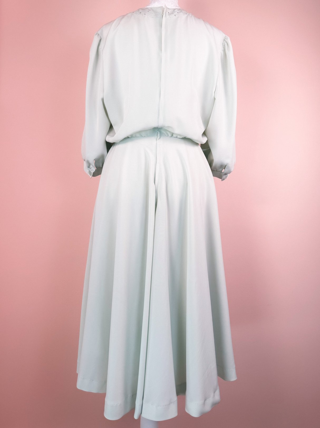 Mint green 1980s women's dress featuring a relaxed silhouette and a cinched waist.