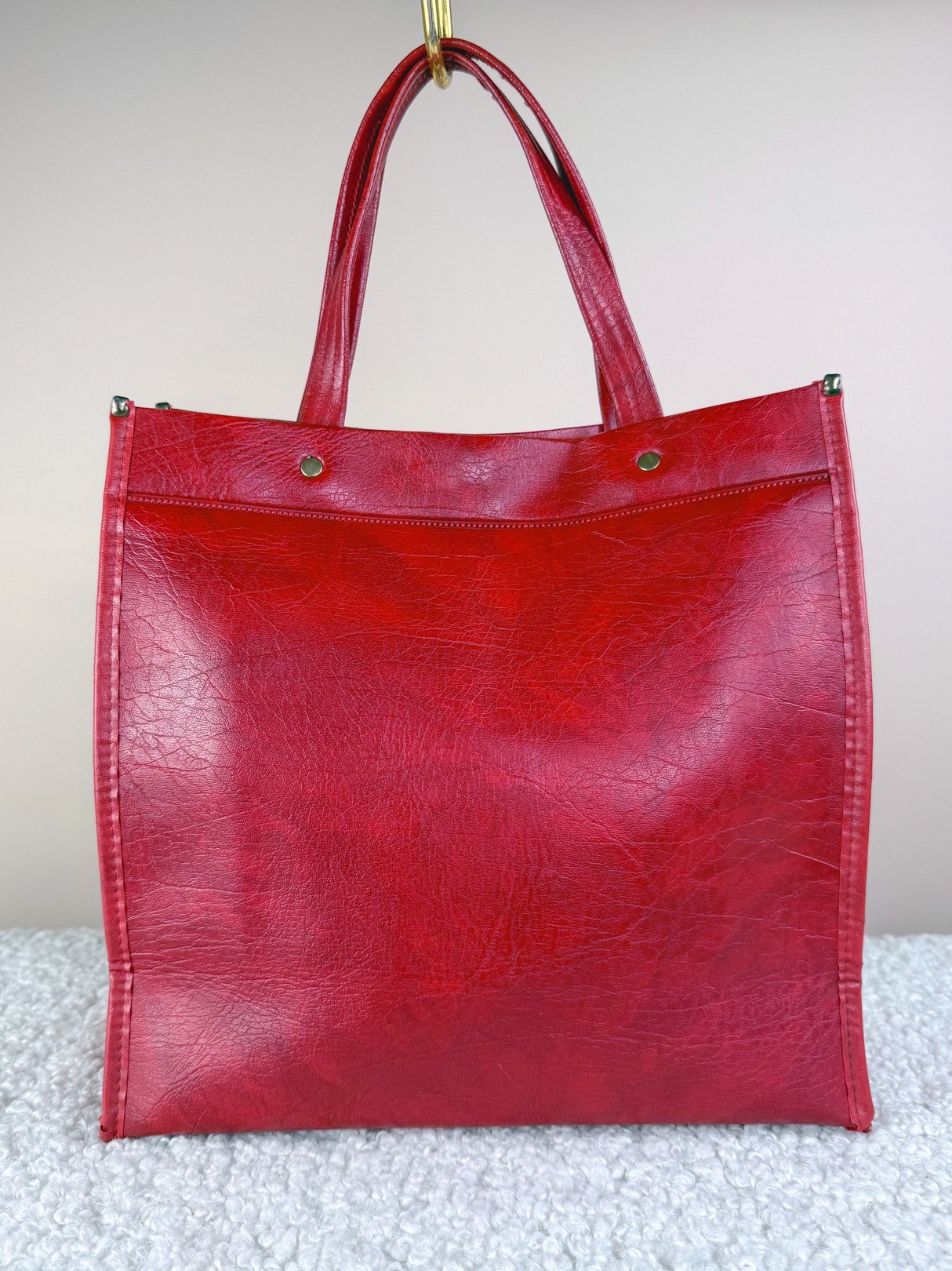 Redline Retro Satchel Tote in red leather with minimalistic design, featuring two handles and a zippered pocket along the top, reflecting a 1970s style.