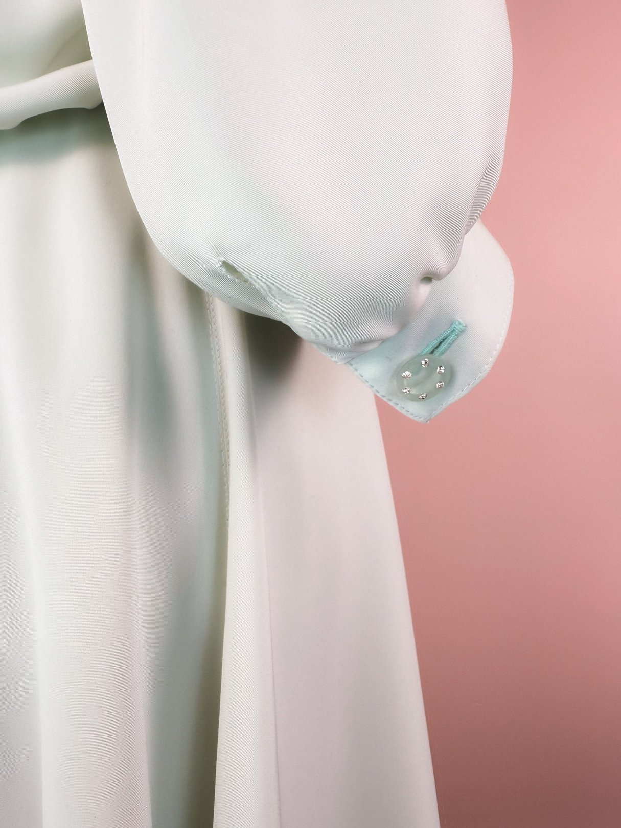 Mint green 1980s women's dress featuring a sparkling finish and embellished cuff detail.